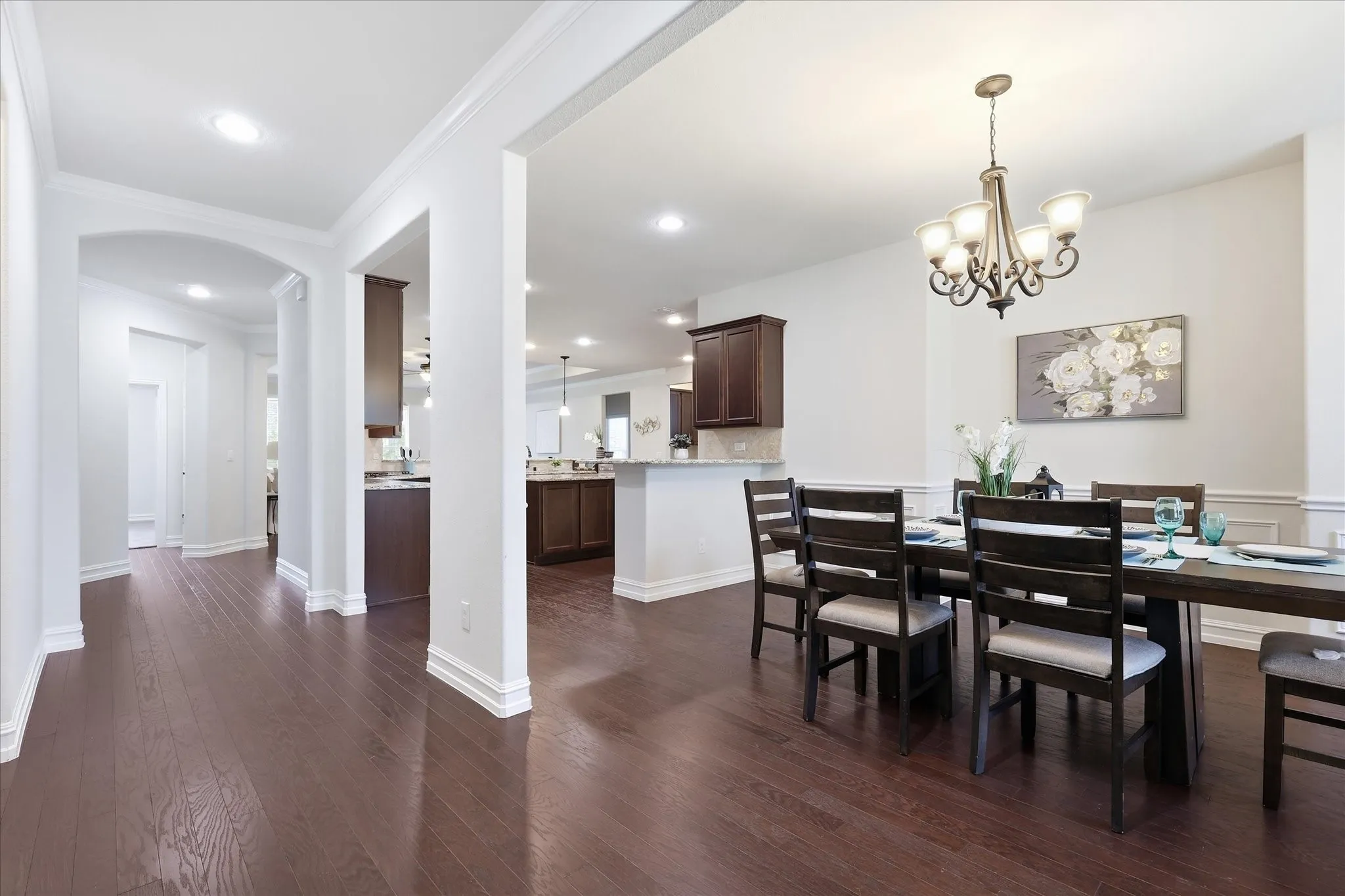 Formal dining area with an overhead chandelier and chair rail molding