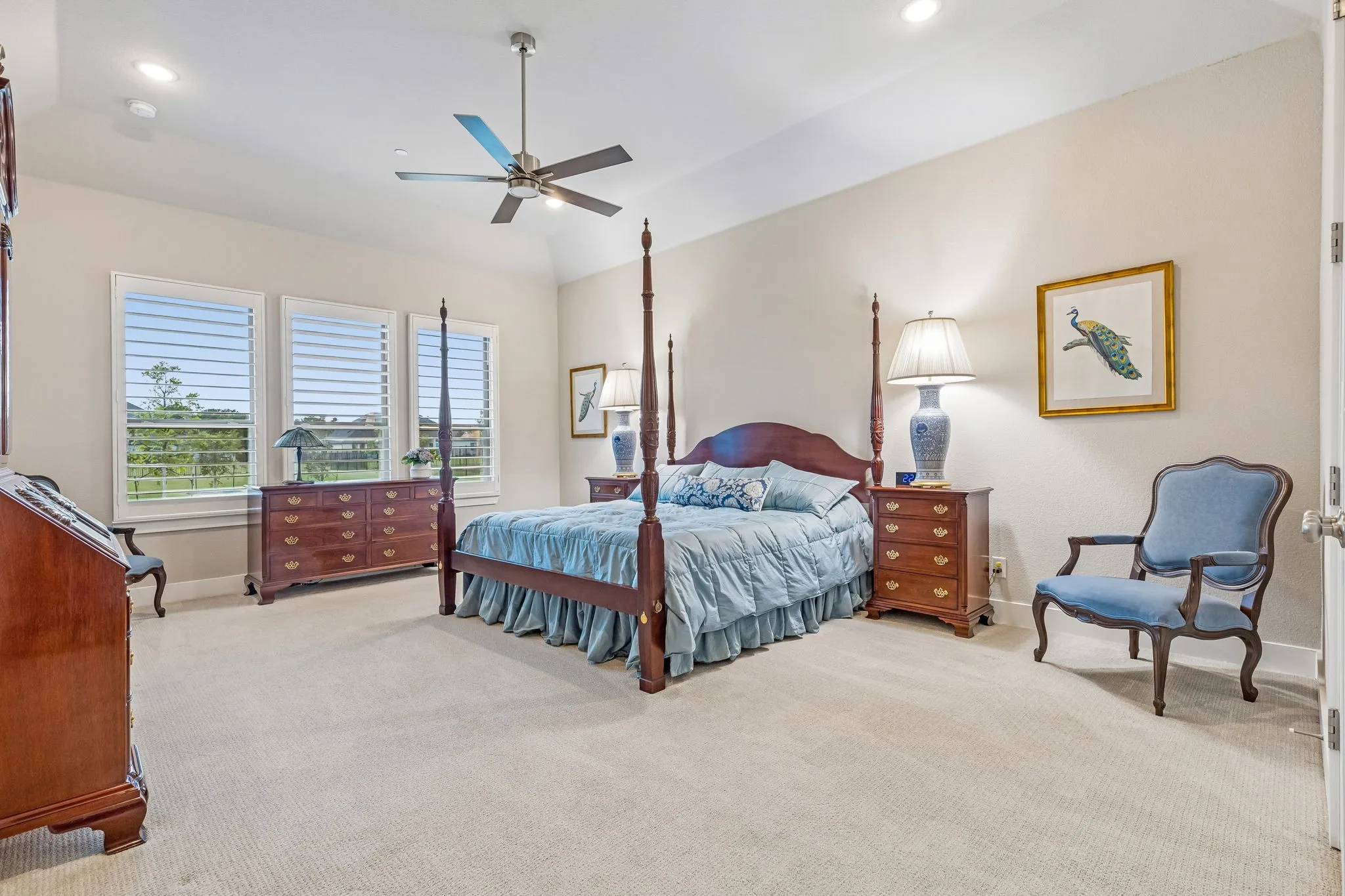 Tucked away for privacy, the primary suite offers a sitting area, spa bath, and views of the beautifully landscaped acreage.