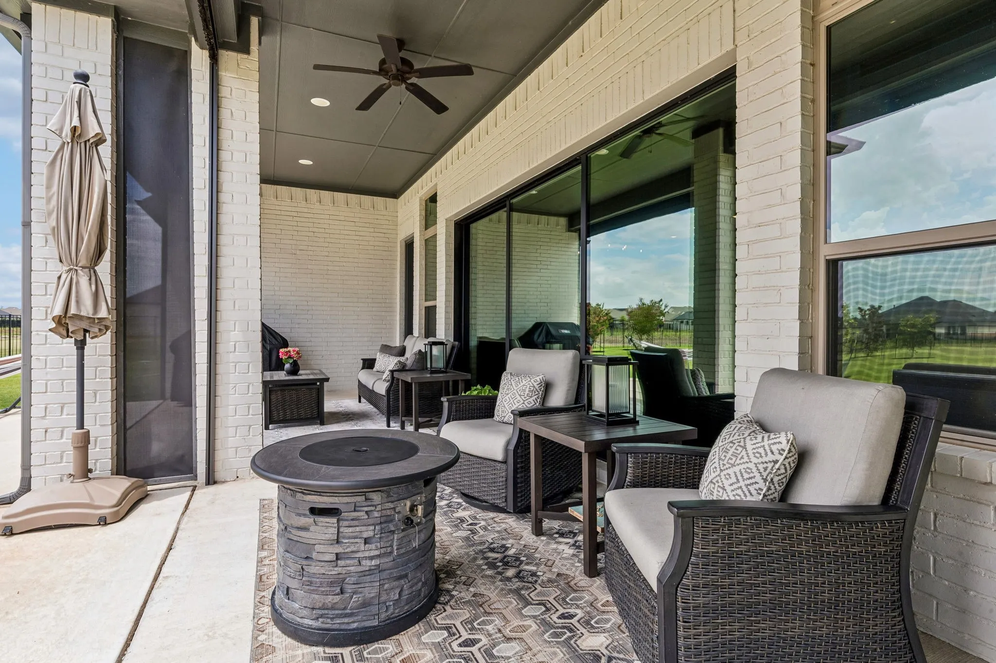 Large covered patio with sun-blocking electric shades overlooking the expansive backyard.