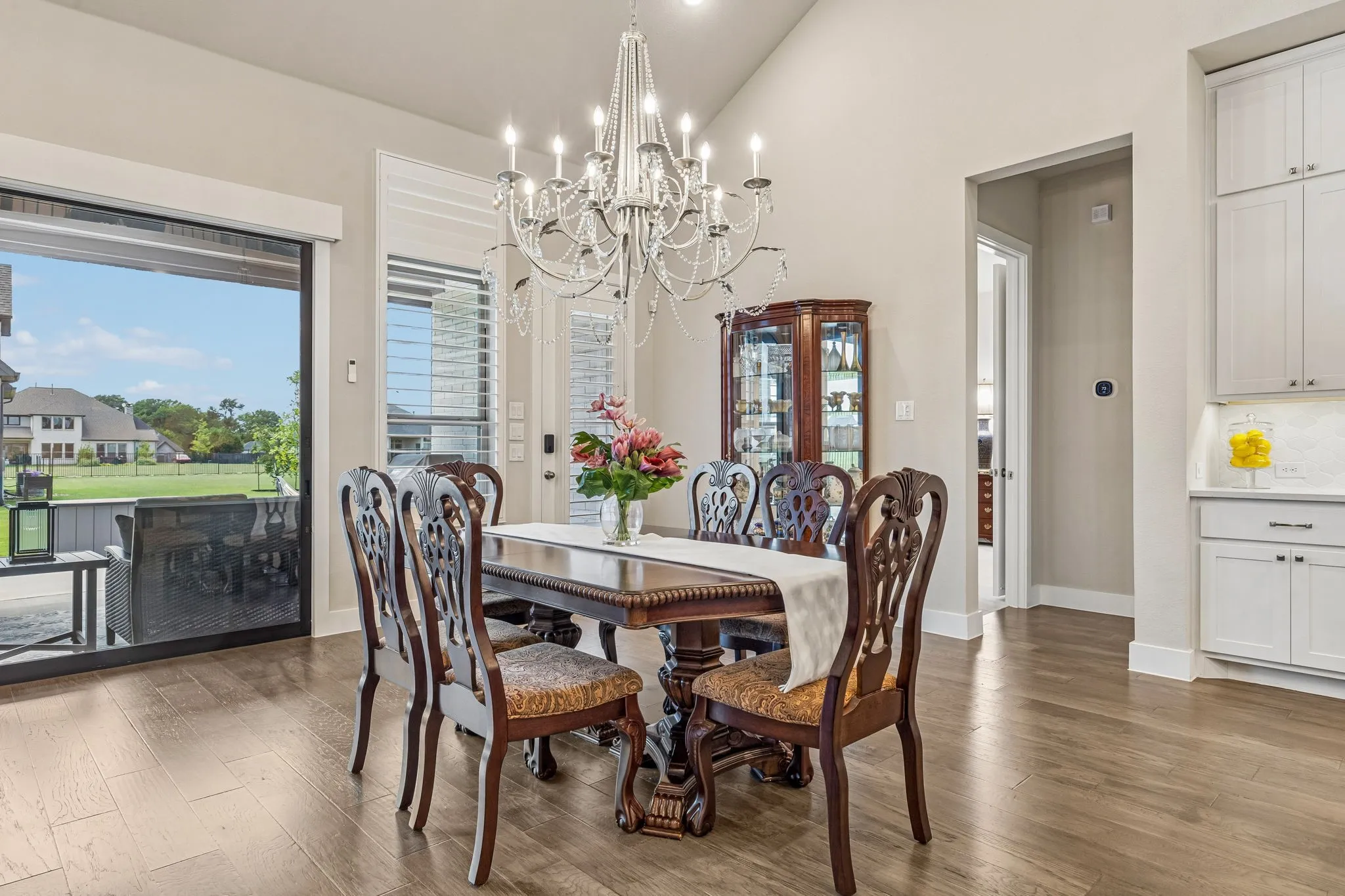 Spacious breakfast room with vaulted ceilings and sliding doors to the large covered patio with sun-blocking electric shades.