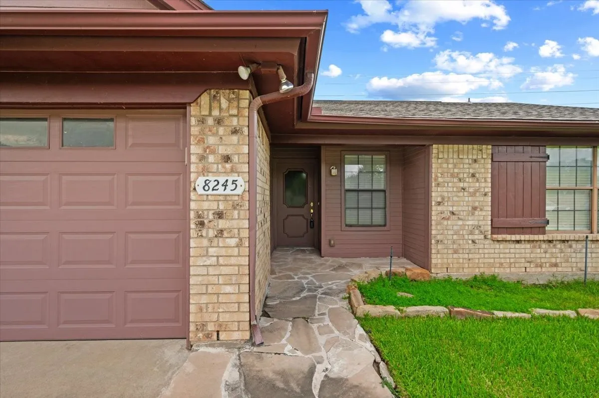 Brick and siding exterior featuring a natural stone pathway