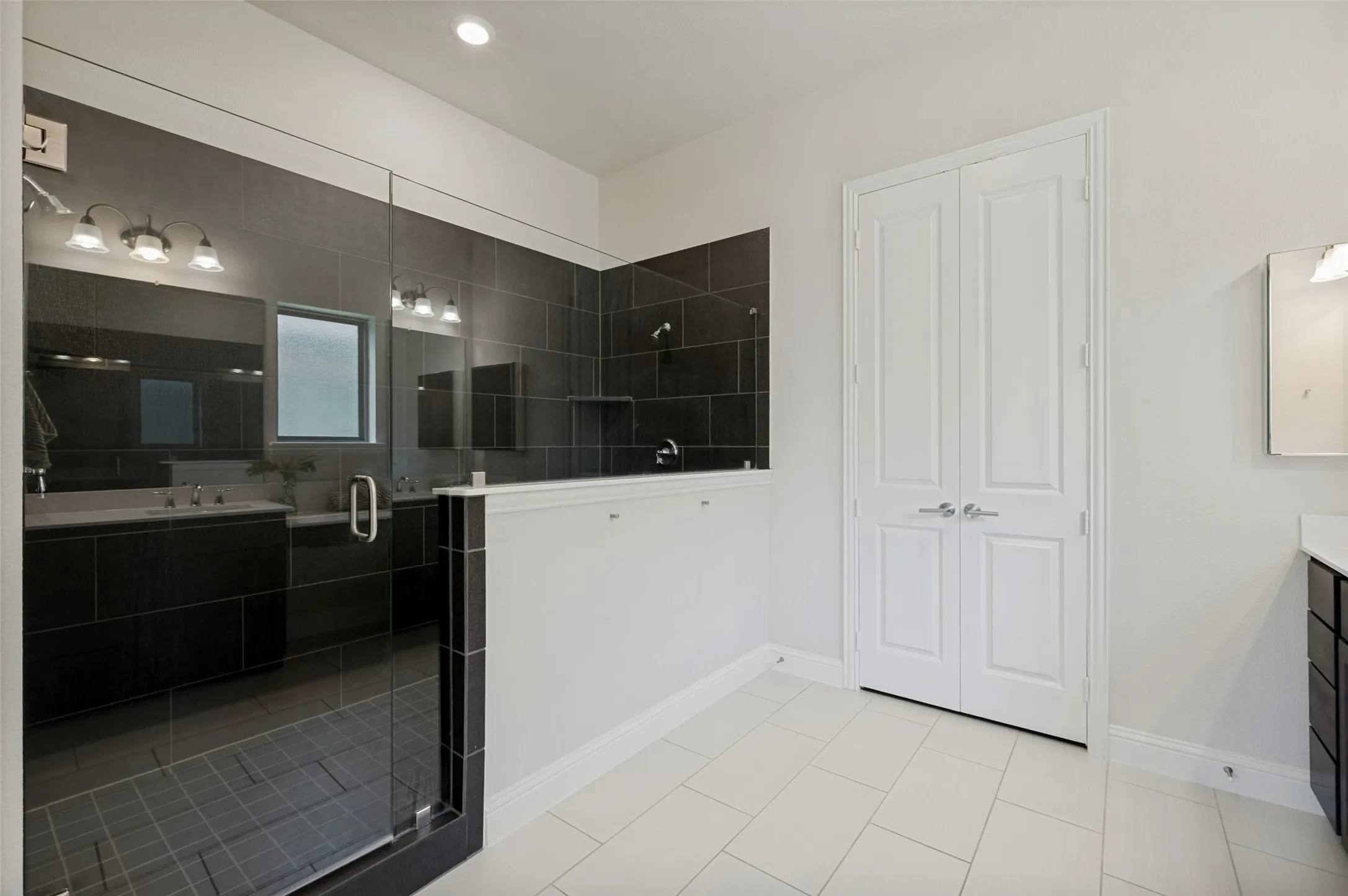 Spa-inspired primary bath featuring an oversized walk-in shower, dual vanities, and ample storage.