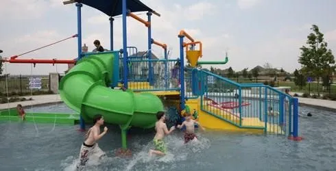 Adventure playground with slides, climbing features, and shaded gathering areas for all ages to enjoy.