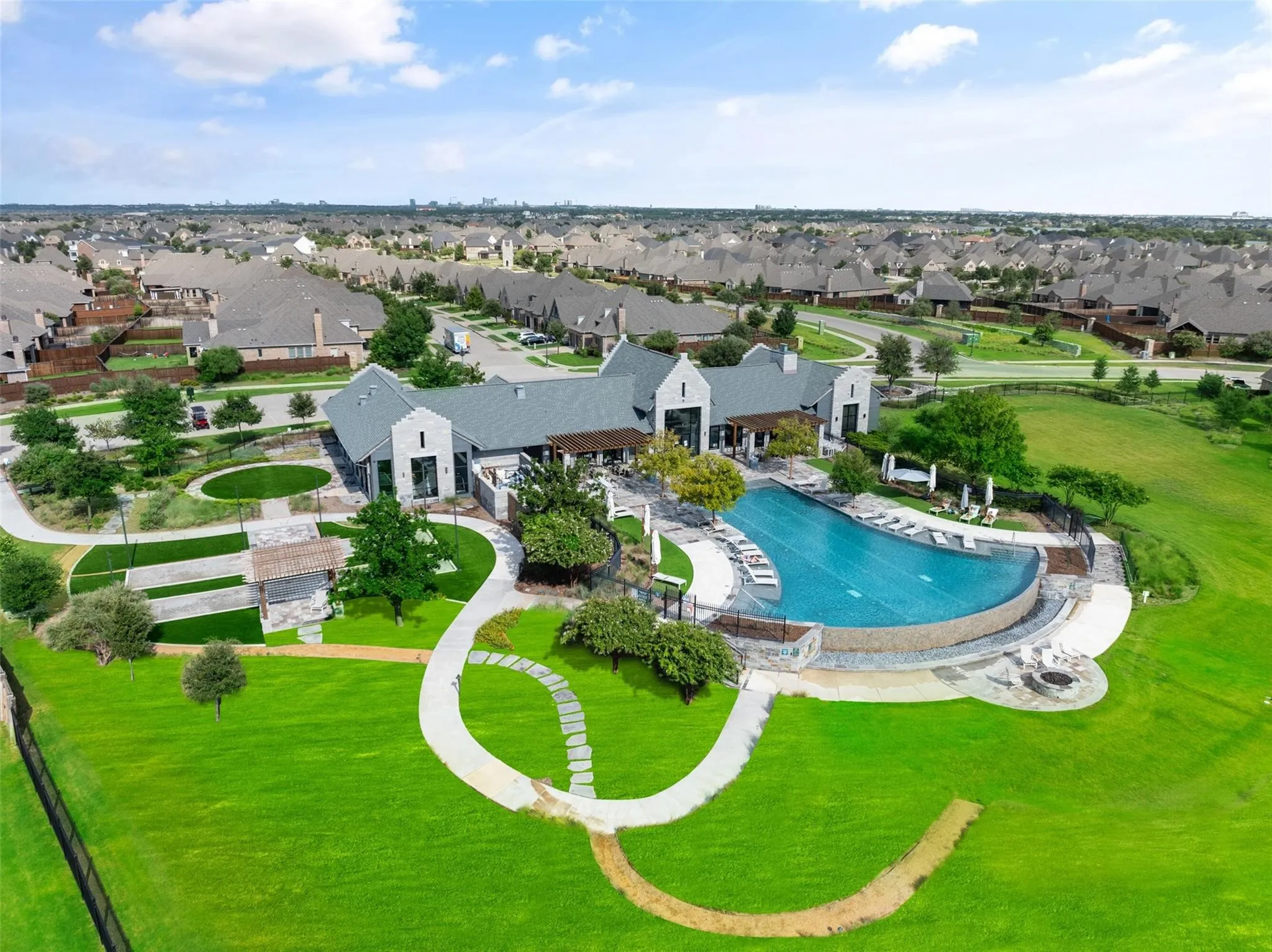 Expansive community pool and clubhouse surrounded by beautifully maintained green space and walking paths.