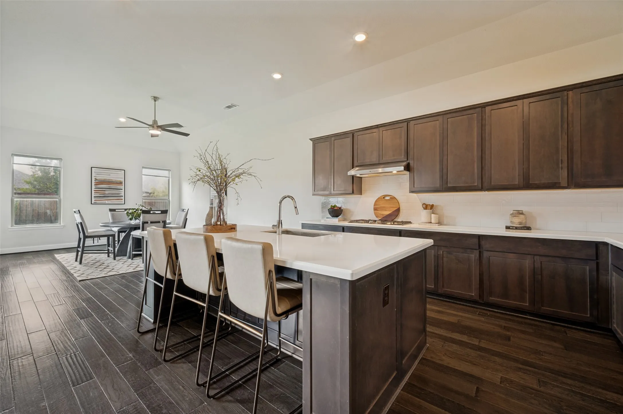Gourmet kitchen featuring a large island with seating, quartz countertops, stainless steel appliances, and ample cabinet space.