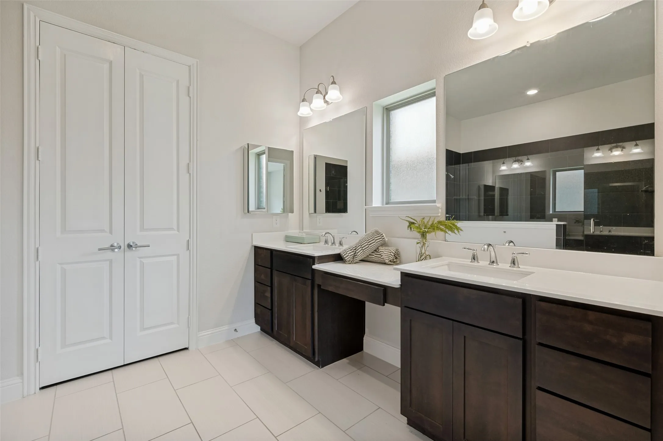 Elegant primary bathroom with dual sinks, quartz countertops, and generous cabinet space.