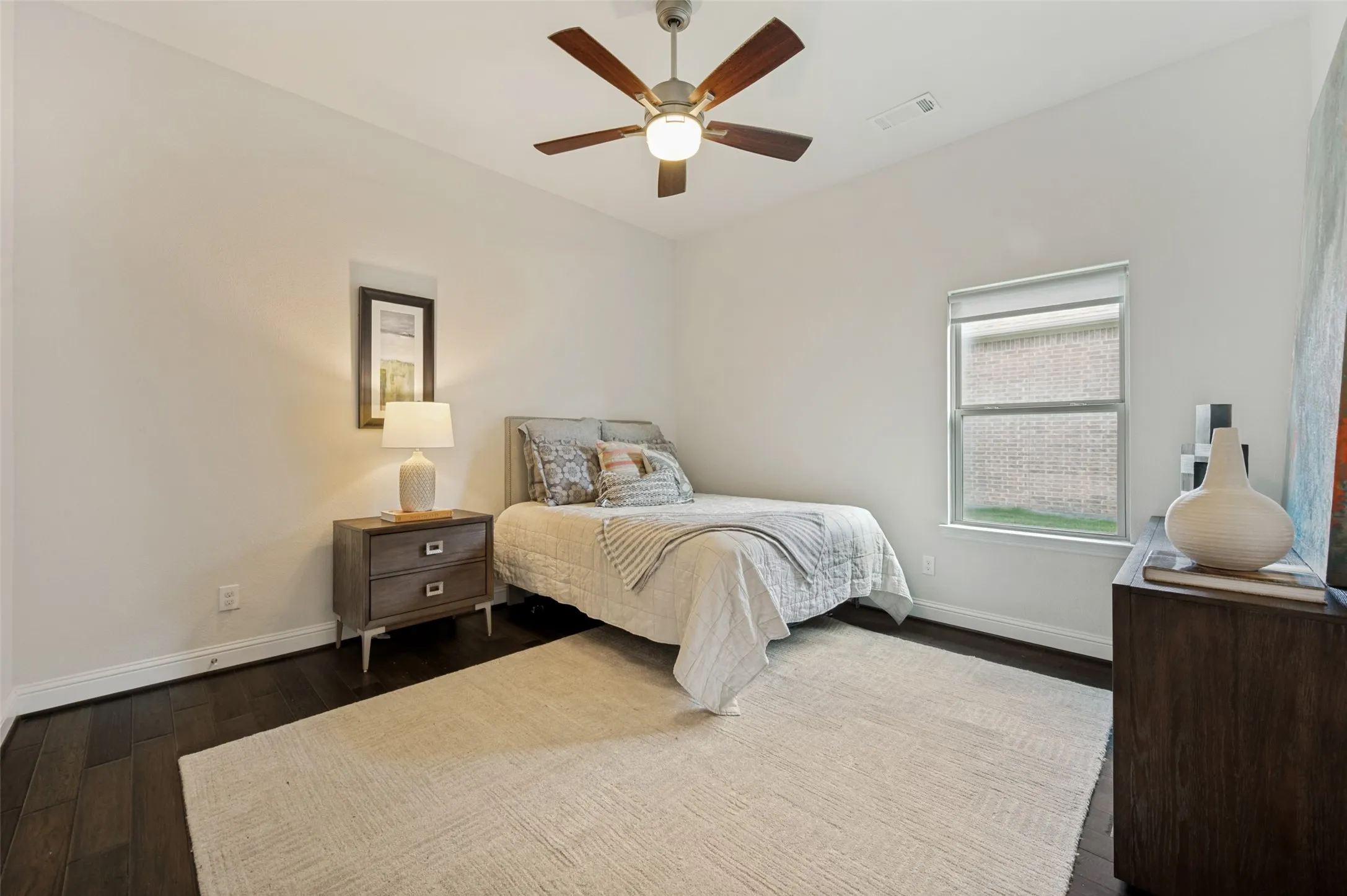 Secondary bedroom with wood flooring, ceiling fan, and plenty of natural light.