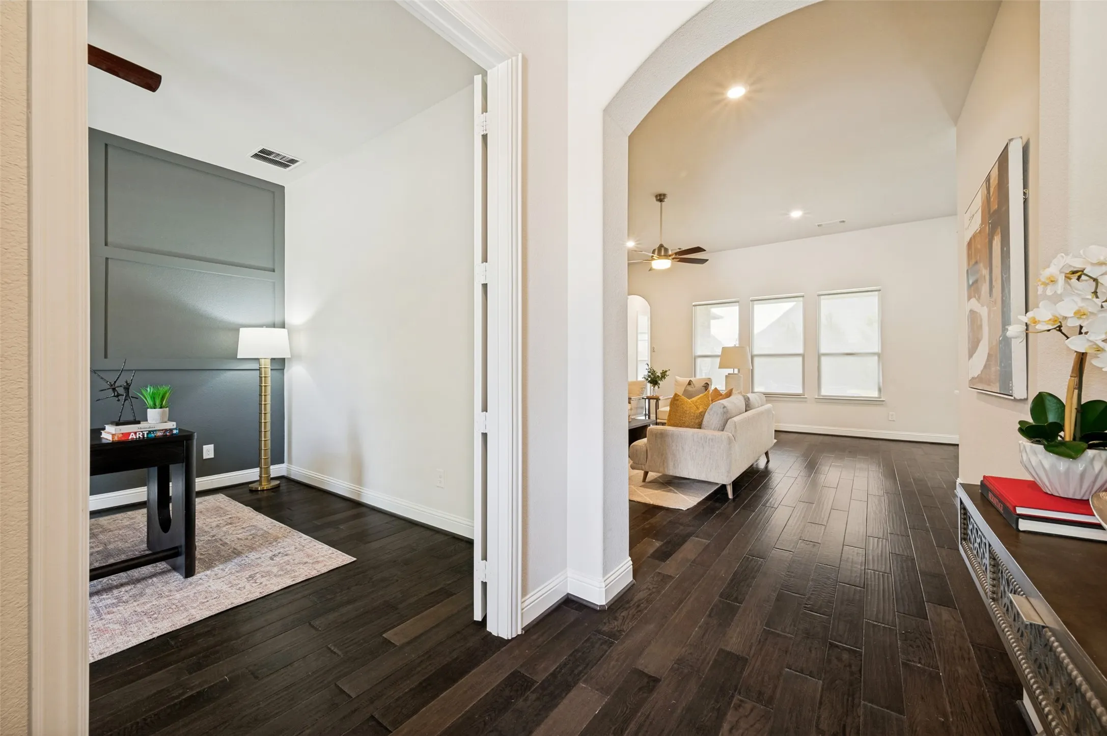 Welcoming entryway featuring rich wood floors, soaring ceilings, and a versatile office or flex space.