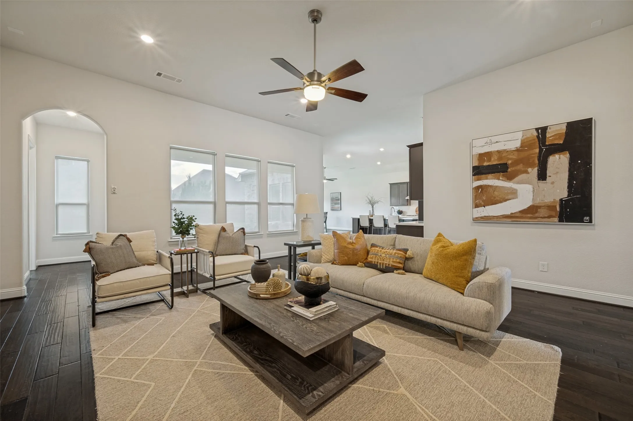 Spacious family room with vaulted ceilings, floor-to-ceiling stone fireplace, and an open-concept layout.