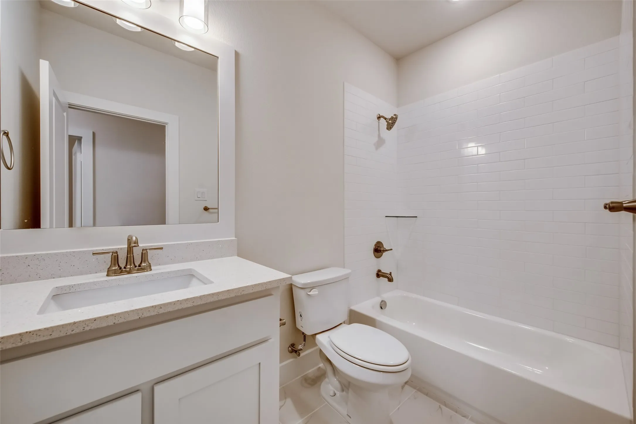 Bathroom featuring a white vanity with a light-toned countertop, a rectangular undermount sink, and a framed mirror