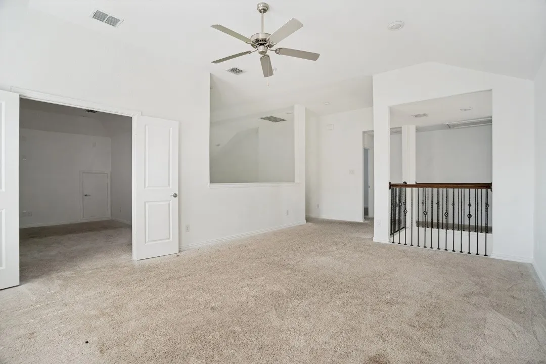 Carpeted interior space with high vaulted ceilings and a ceiling fan