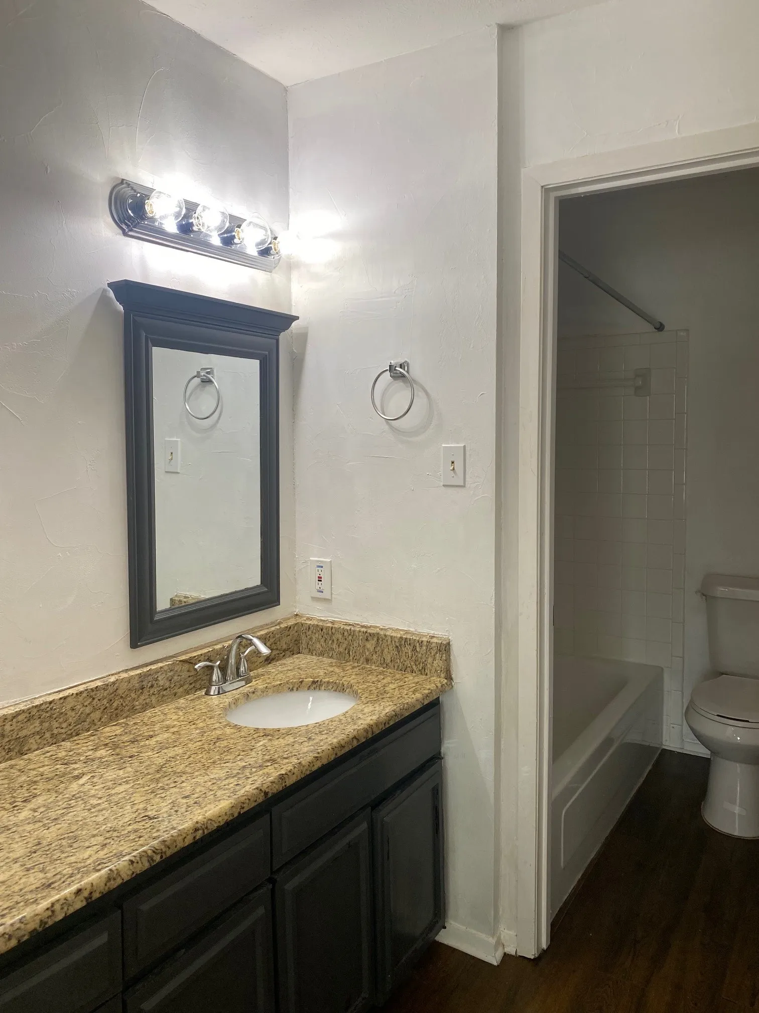 Full bathroom with vanity, washtub / shower combination, and dark wood-style floors