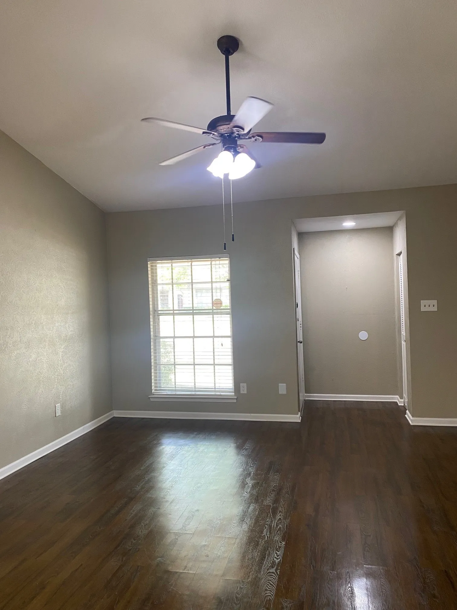 Unfurnished room with dark wood finished floors and a ceiling fan