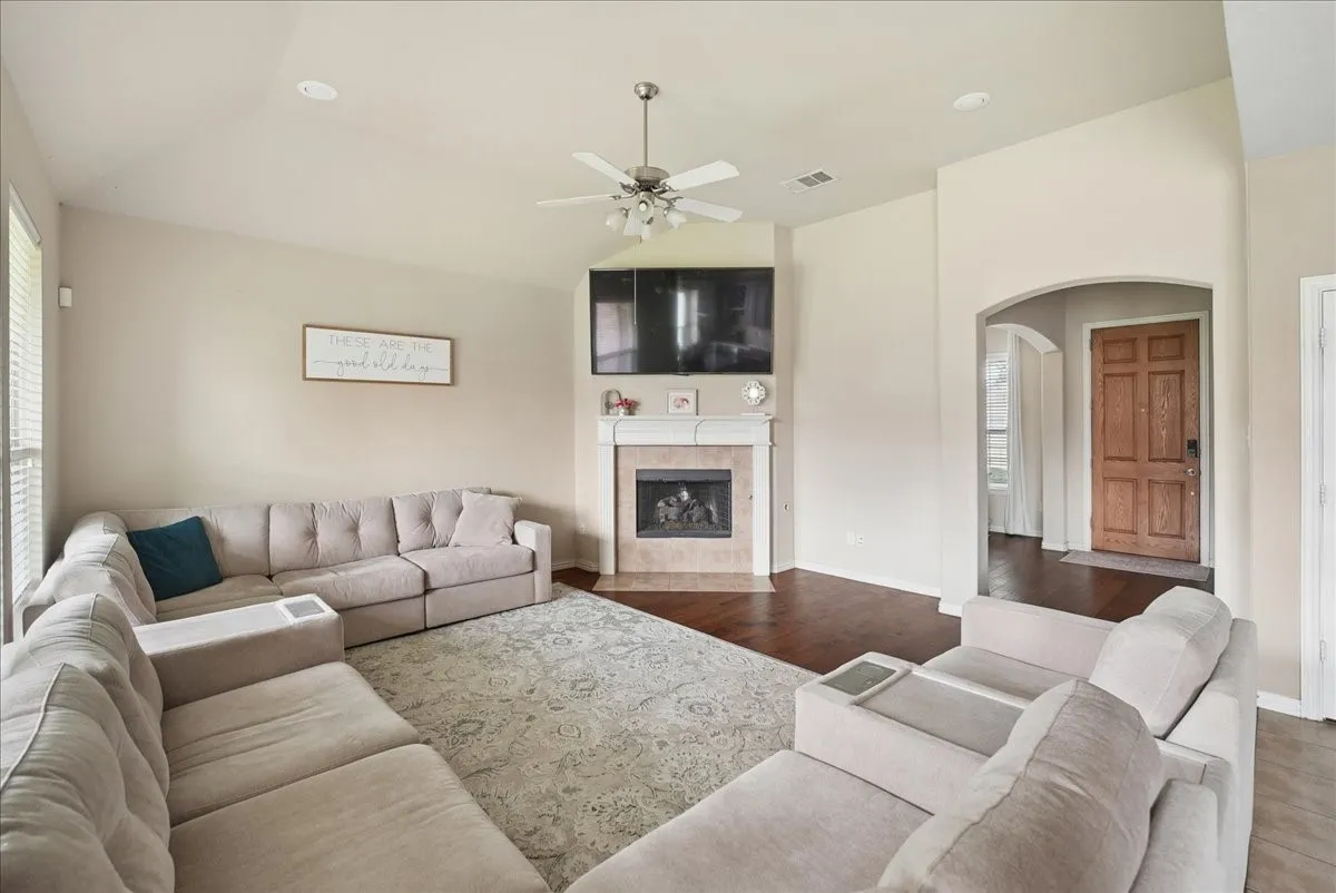 Living space featuring wood-finish flooring and a corner fireplace with a mantel