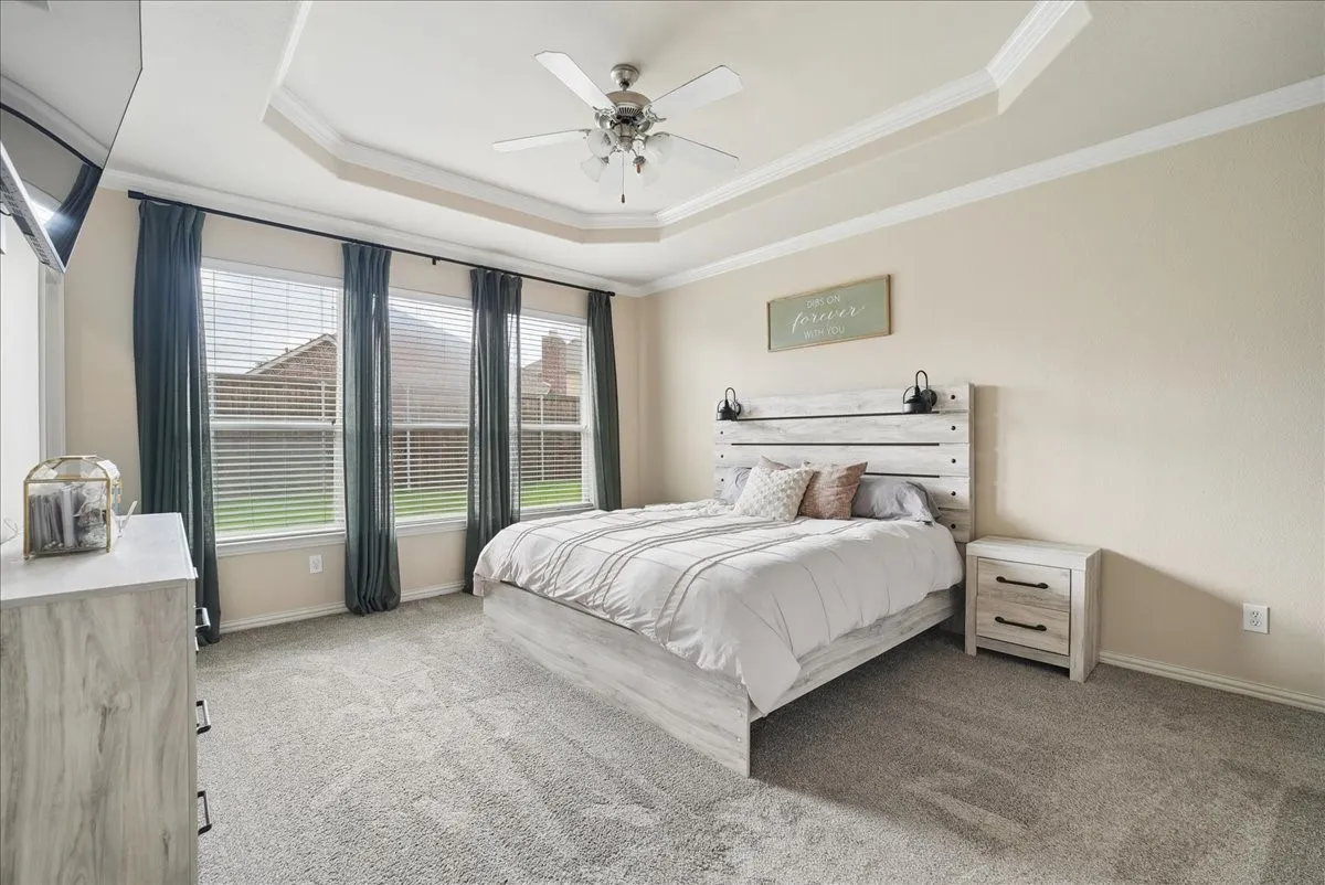 Tray ceiling with crown molding and a ceiling fan