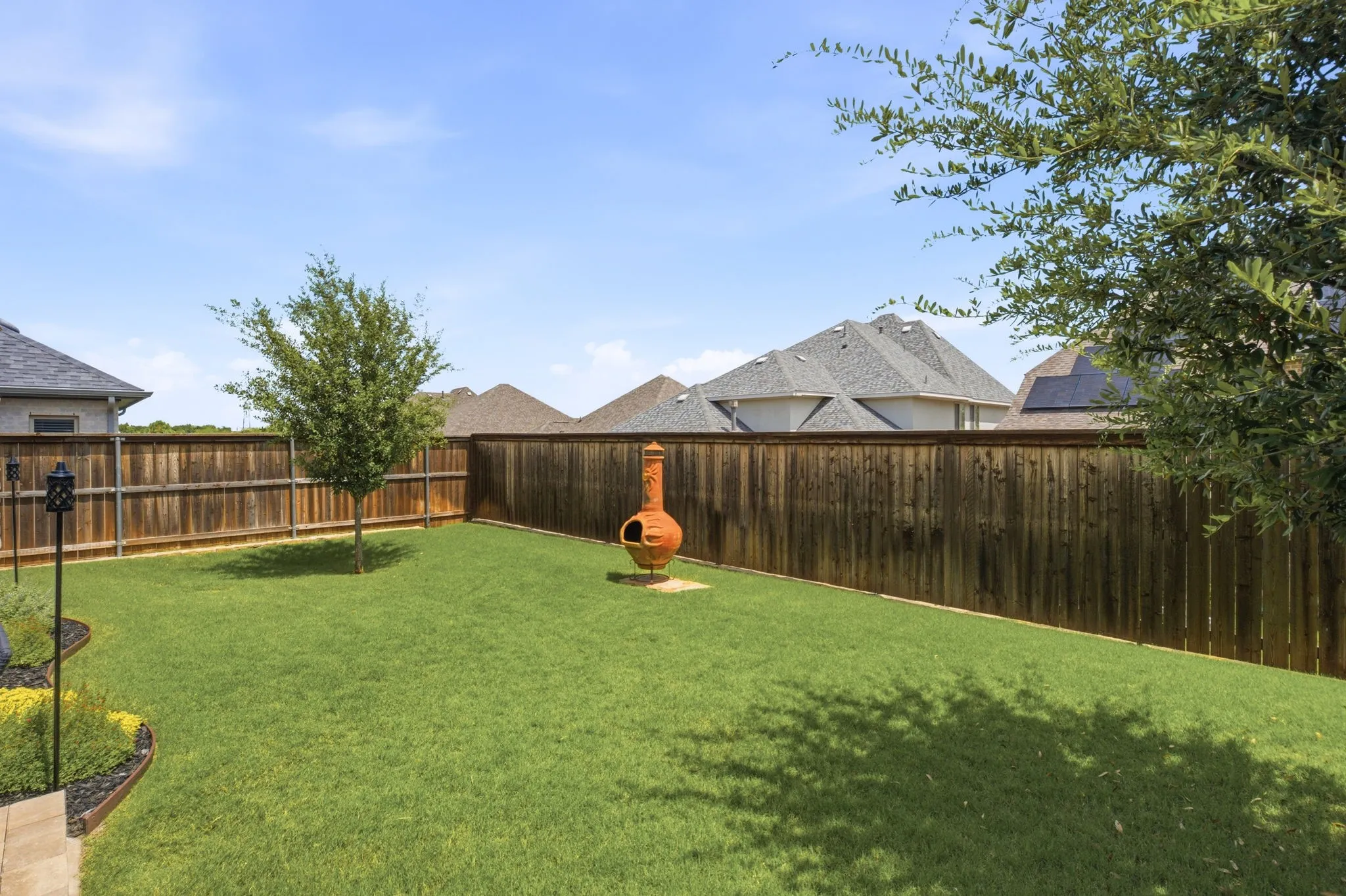 The backyard is perfectly balanced between open grassy areas for play + thoughtfully landscaped garden beds off the open patio.