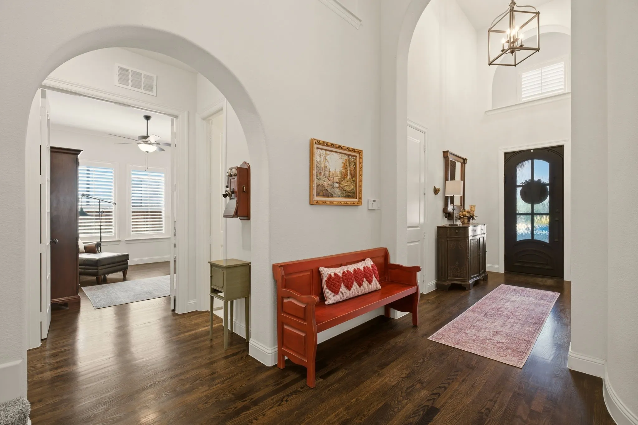 Elegant architectural arches in the foyer create a distinctive first impression, adding depth, character, & timeless appeal to the home's entryway. Gleaming nailed-down, sanded & stained hardwood floor extend from the entry hall through the office, primary & kitchen.