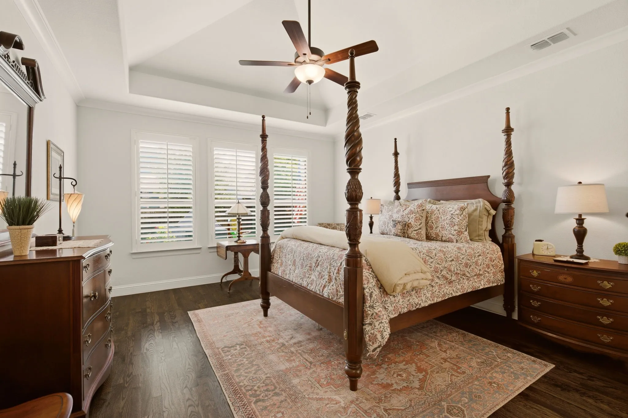 Tucked in the back, the primary bedroom also has beautiful hardwoods & a tray ceiling.