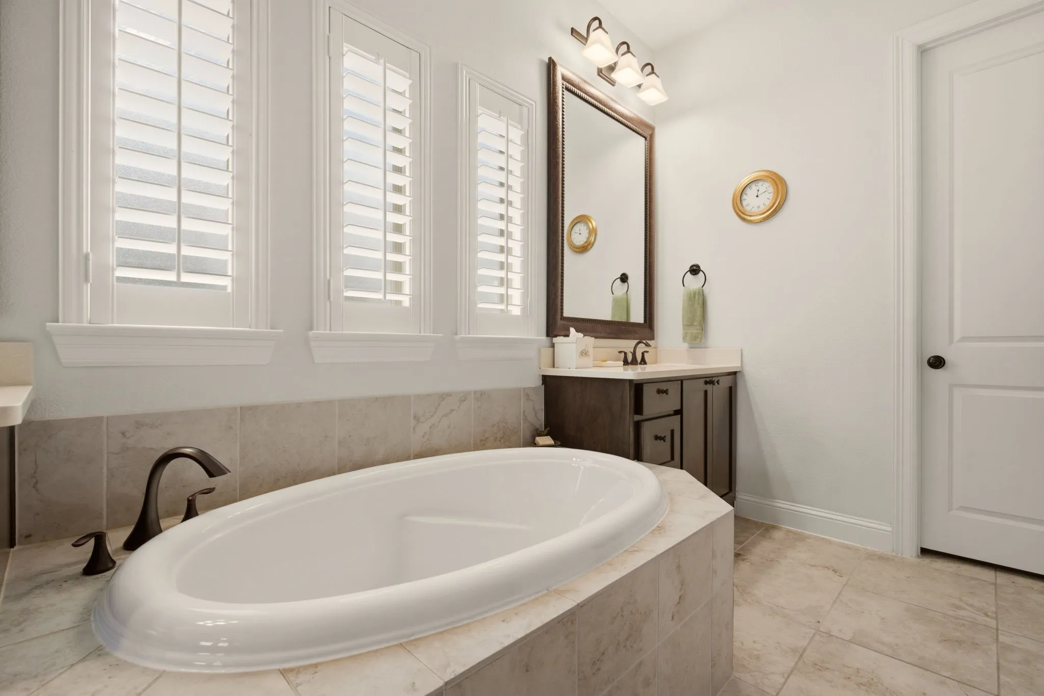 Bathed in natural light, the immaculate primary bath offers a soaking tub & dual vanities, blending comfort with a fresh, airy feel.