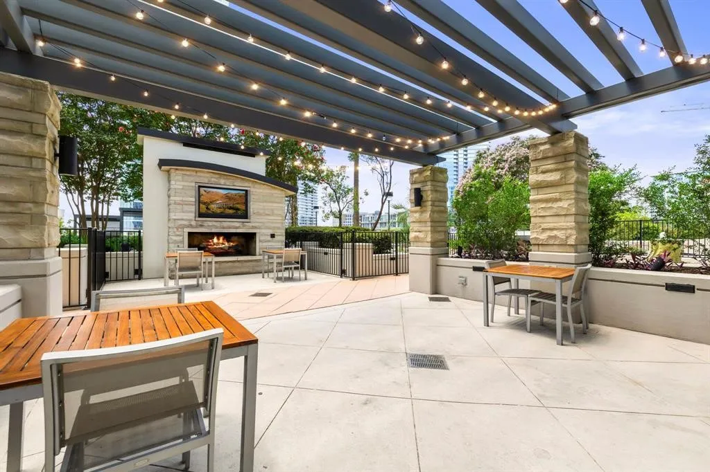 Outdoor patio with an integrated fireplace and television feature