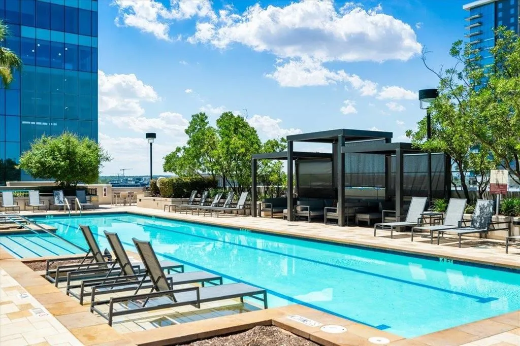 Outdoor swimming pool with integrated lighting, surrounded by stone paver decking