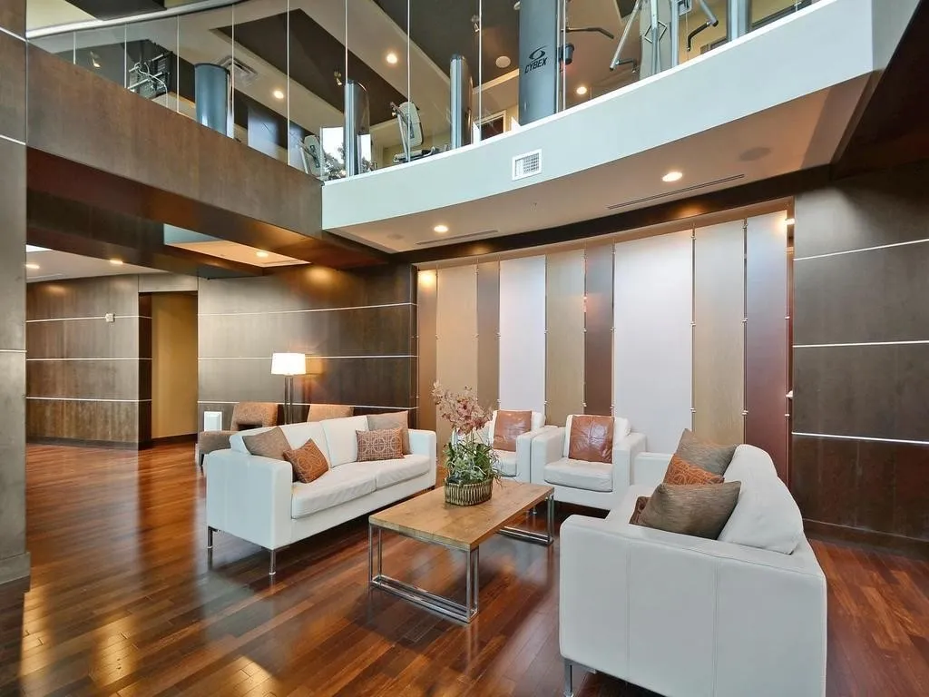 Two-story communal space featuring wood-finish flooring and recessed lighting