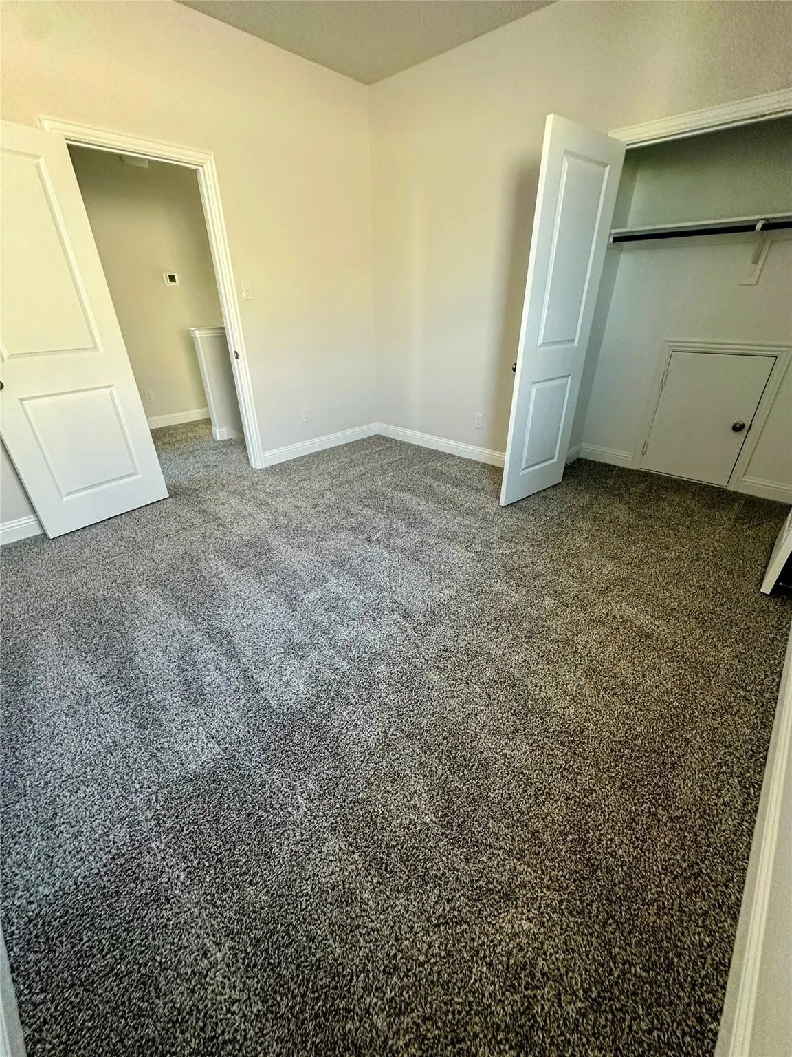 Bedroom featuring neutral-toned walls and plush gray carpeting