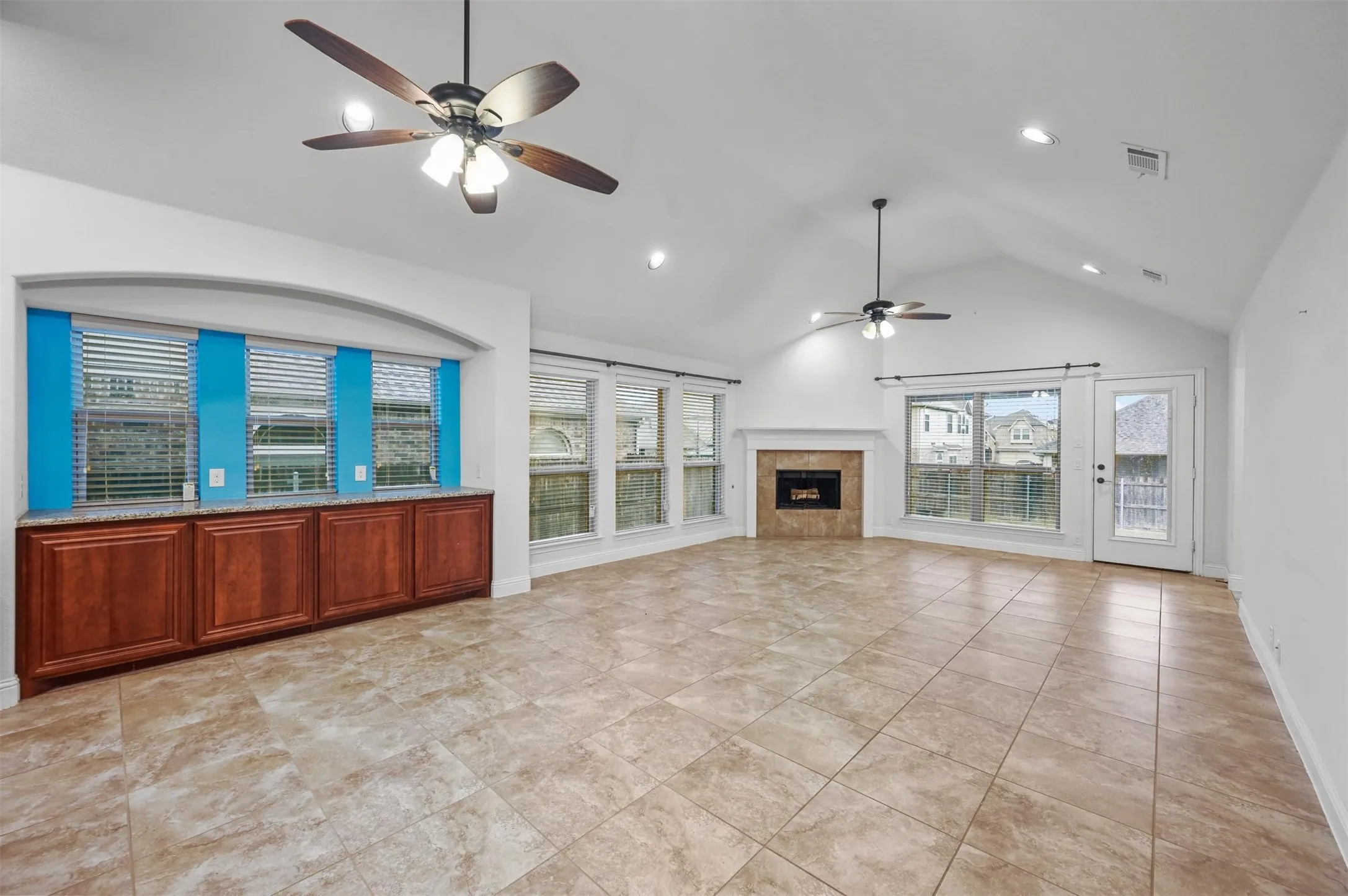 Expansive living area featuring vaulted ceilings, recessed lighting, and large format tile flooring