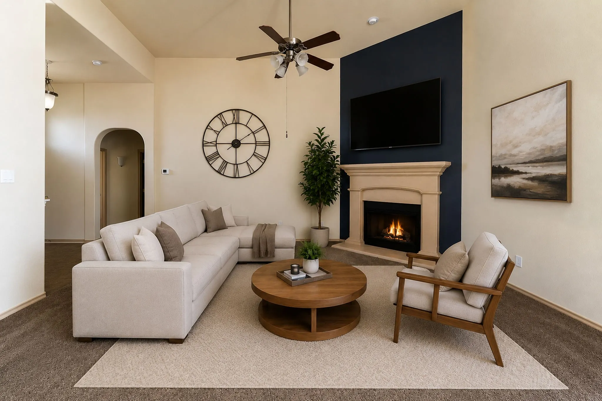 LVirtual Staging of iving area to show how furniture would look.  This area is featuring a gas fireplace with a stone-finish mantel, a dark accent wall, vaulted ceilings, and a ceiling fan with integrated lighting