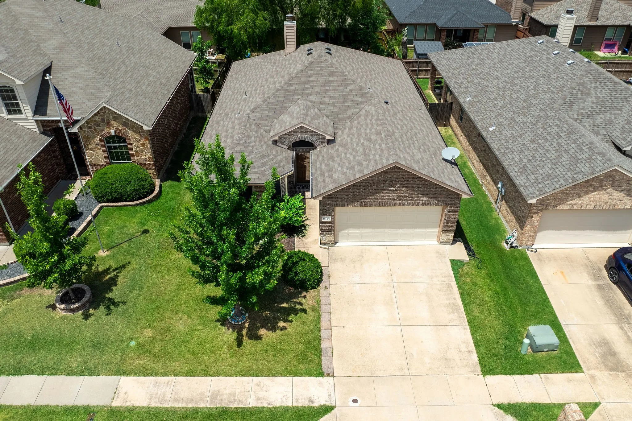 Traditional brick residence featuring a concrete driveway, attached garage, and a gabled roof