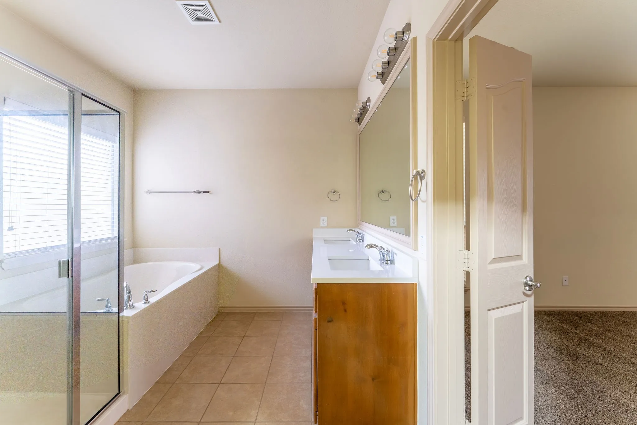 Walk-in closet with textured neutral walls, multiple built-in shelving units, integrated hanging rods, and carpet flooring