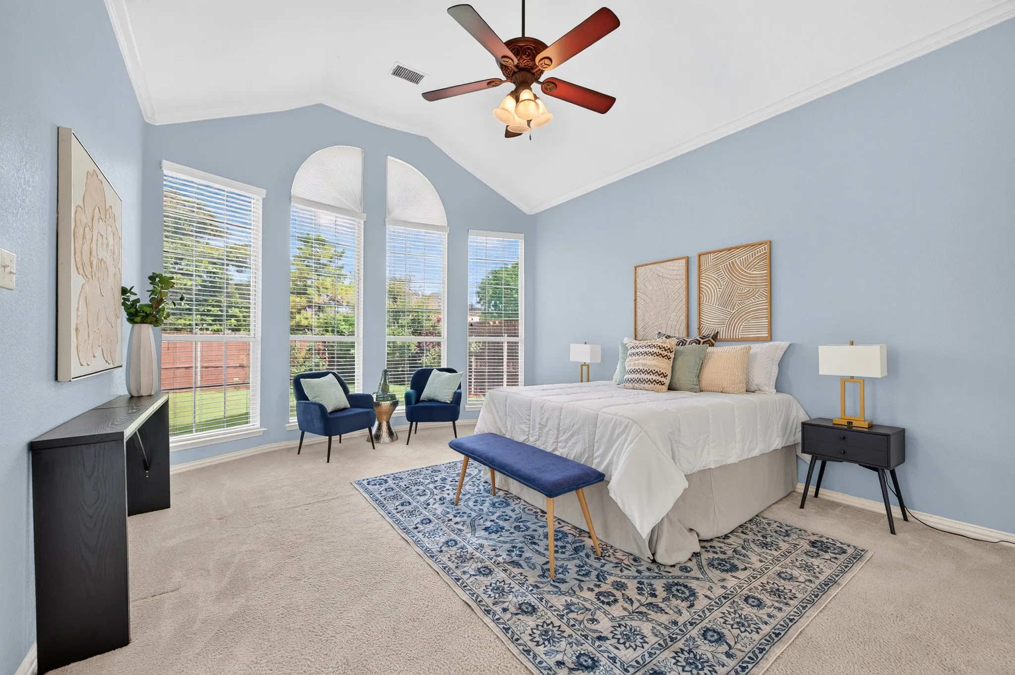 Vaulted ceiling room featuring multiple large windows, soft blue wall tones, and carpeted flooring