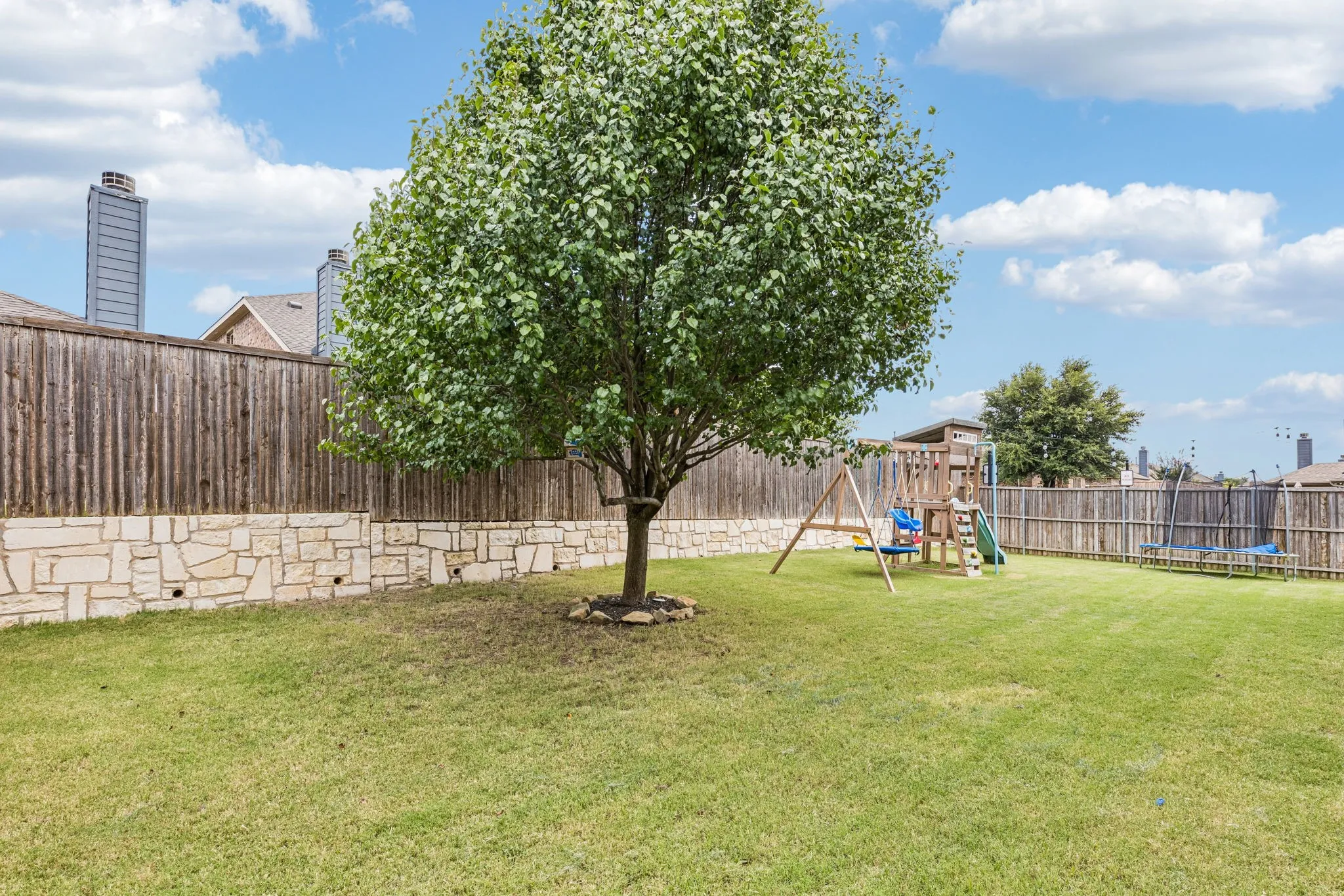 well maintained yard with stone retaining wall