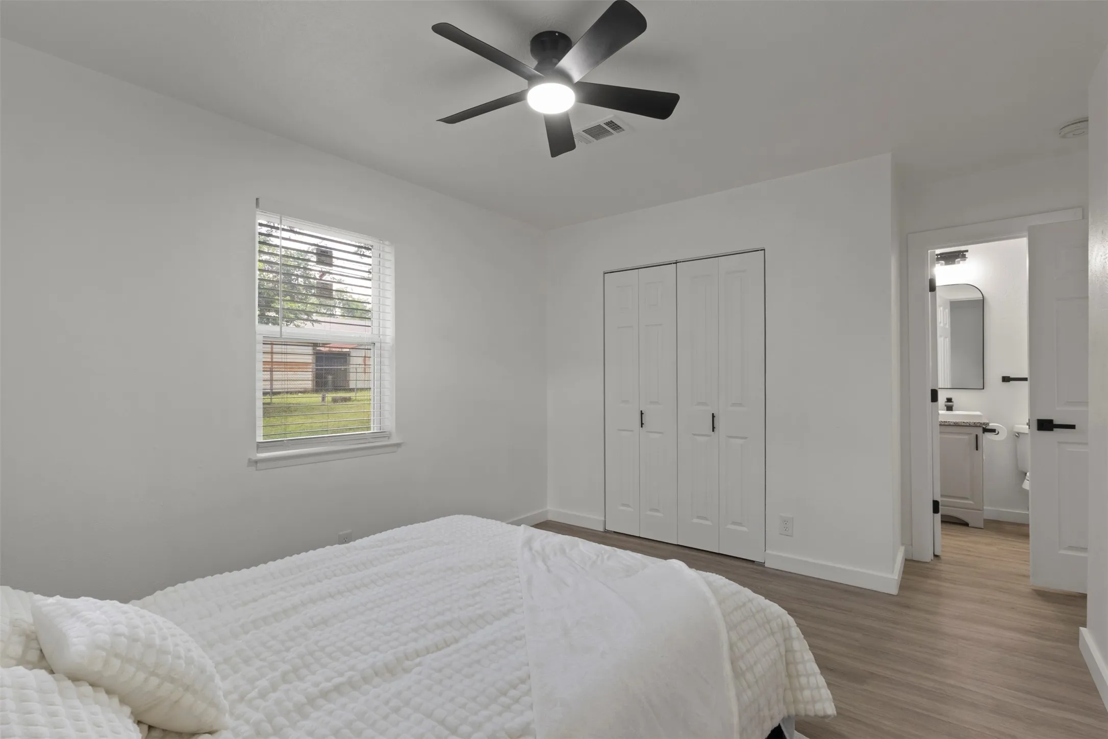 Primary bedroom with luxury vinyl floor windows for natural lighting and a celling fan , with its own private bathroom