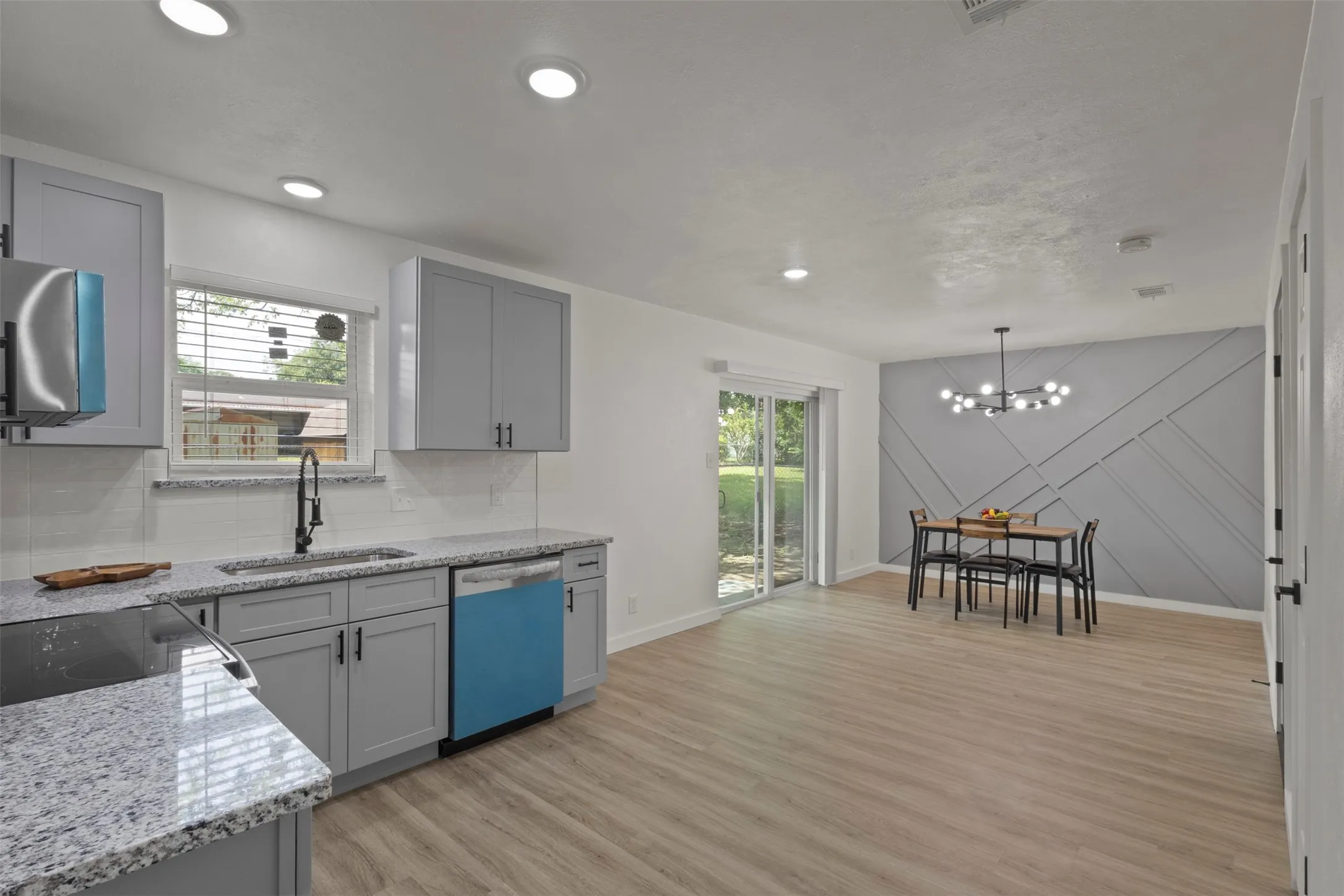 Open kitchen with new cabinets stainless steel appliances that flows into the dining area
