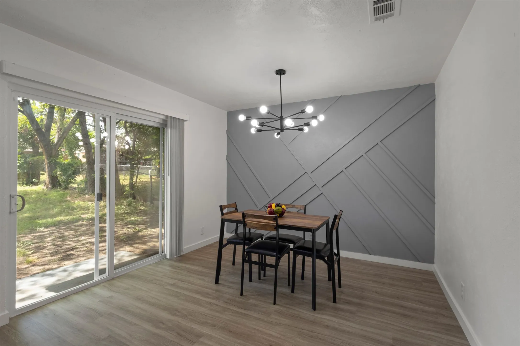 Dining area with a chandelier and accent wall