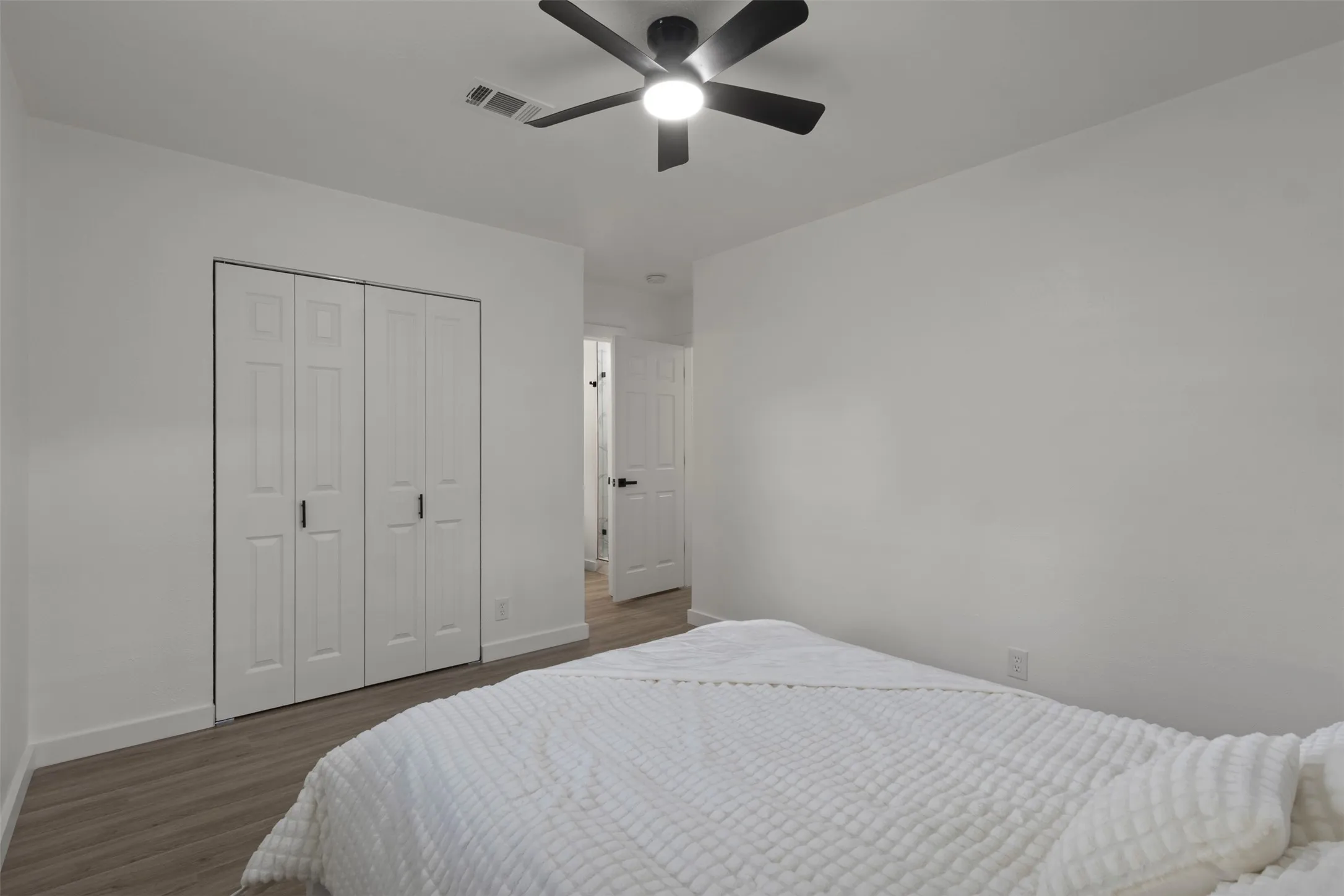 Primary bedroom with luxury vinyl floor windows for natural lighting and a celling fan , and a double door sliding closet