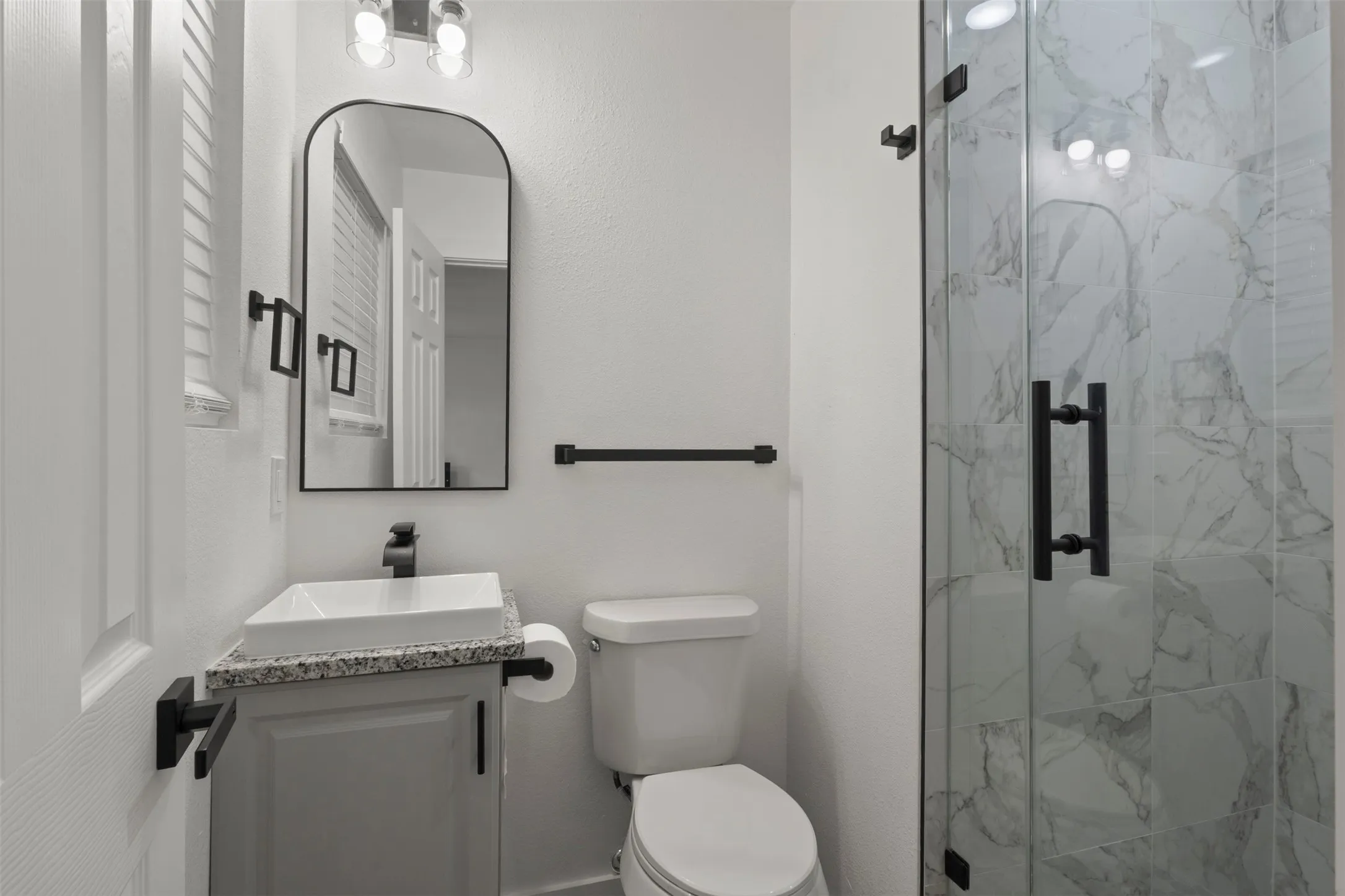 Primary bathroom with a new vanity , and a walk in shower with a glass door