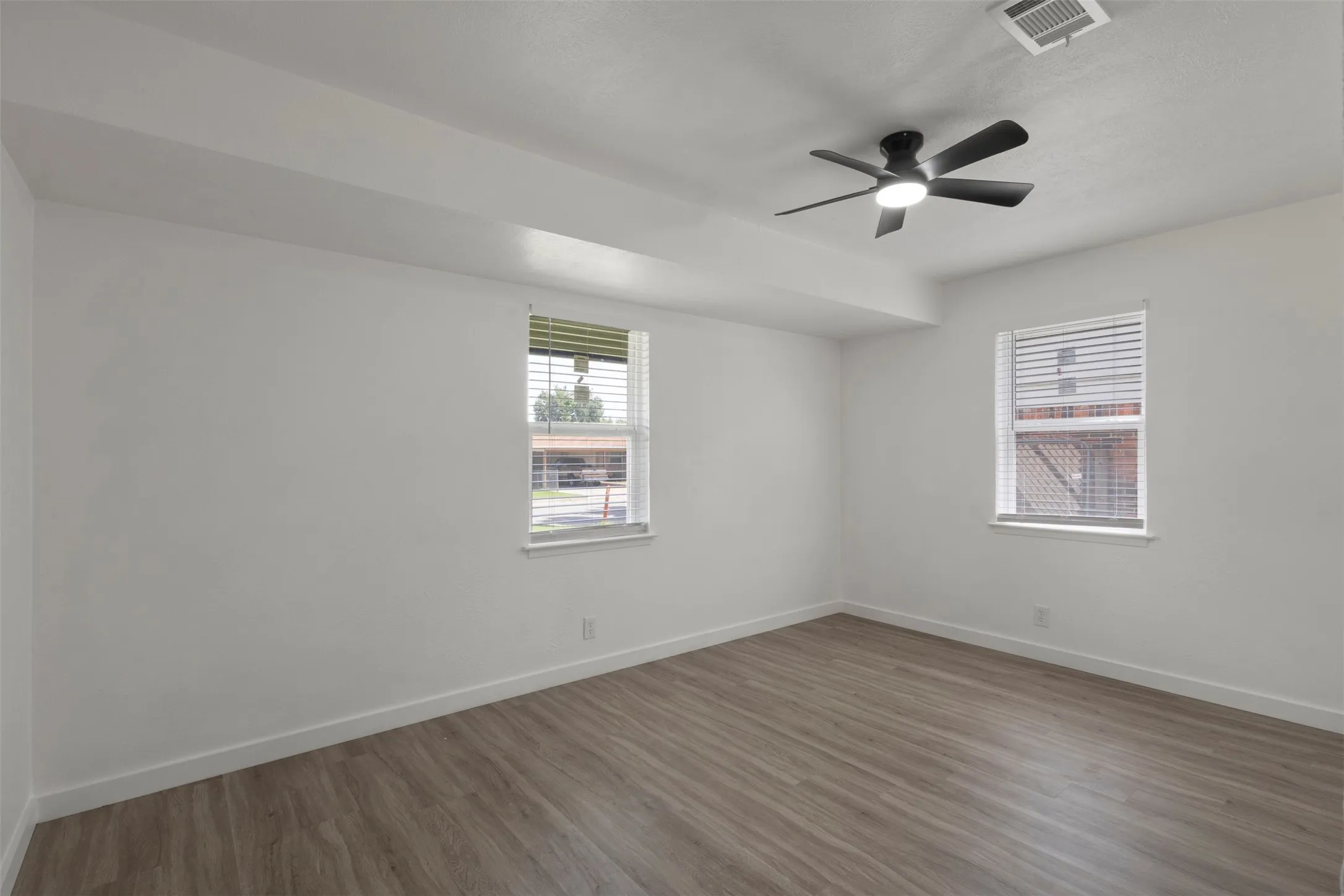 Secondary bedroom with luxury vinyl floor and windows for natural lighting