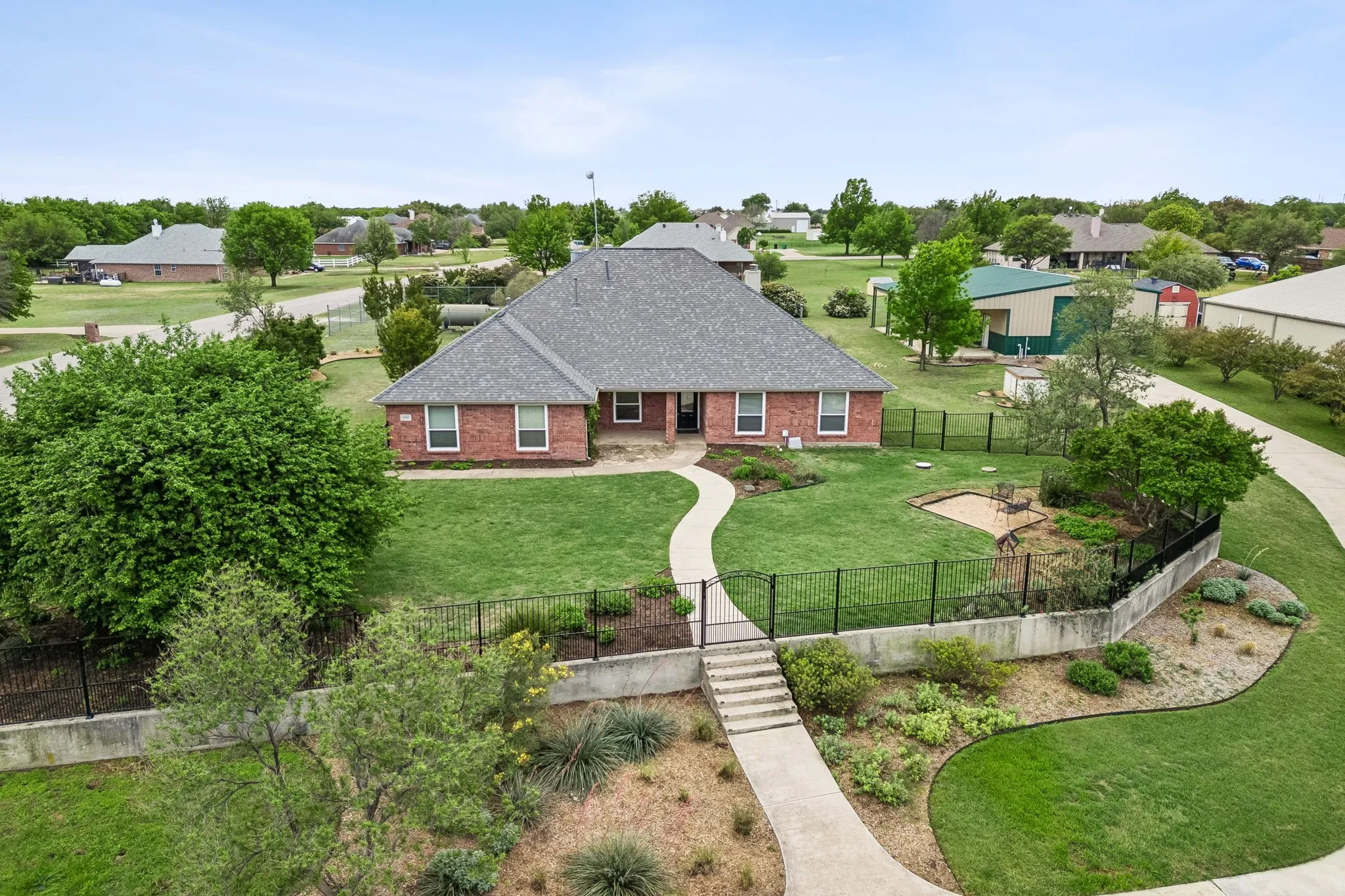 Elevated Homesite With Manicured Landscaping And Wrought Iron Fence