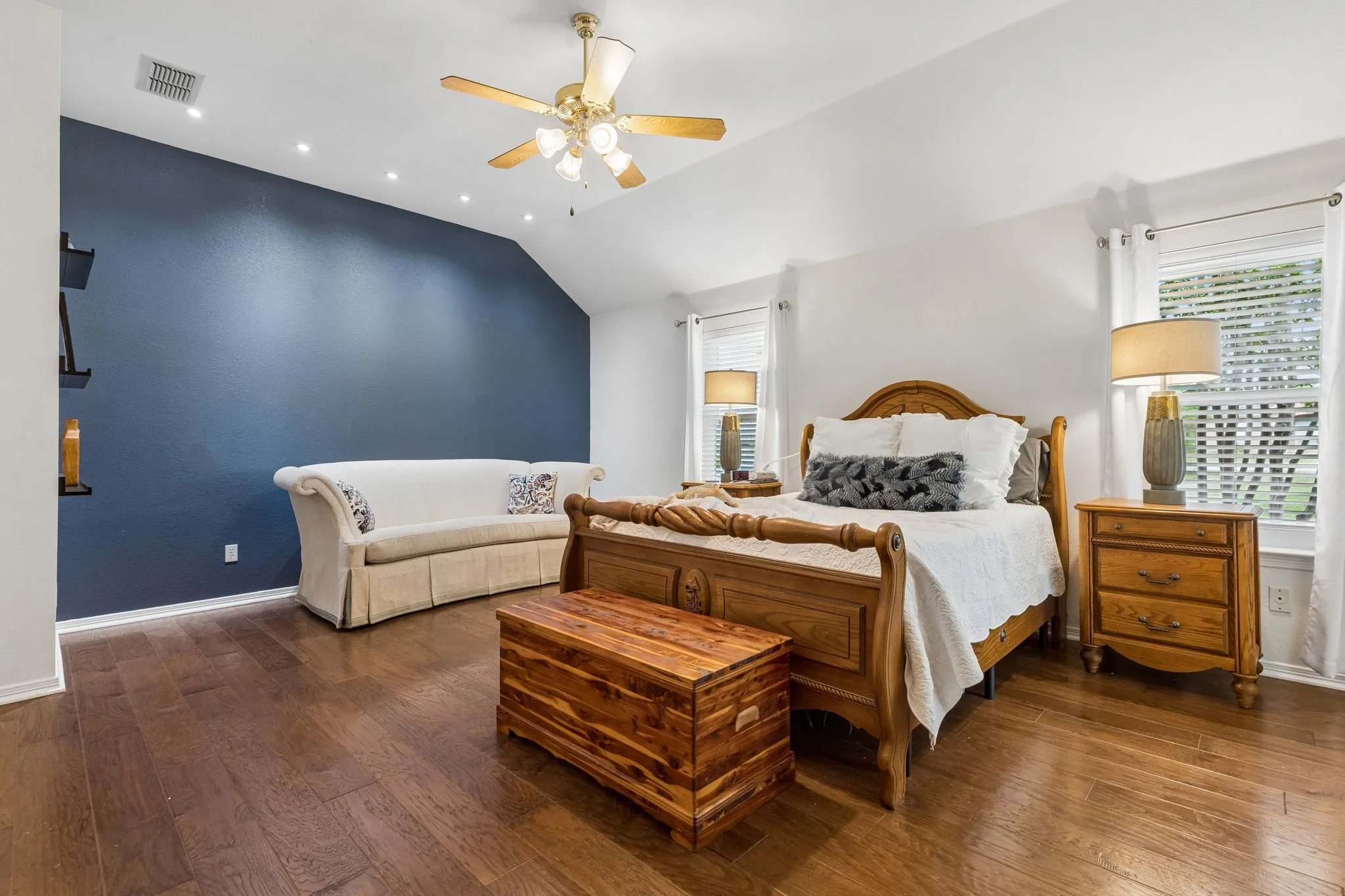Primary Suite Featuring Wood Flooring, Accent Paint, And Ceiling Fan
