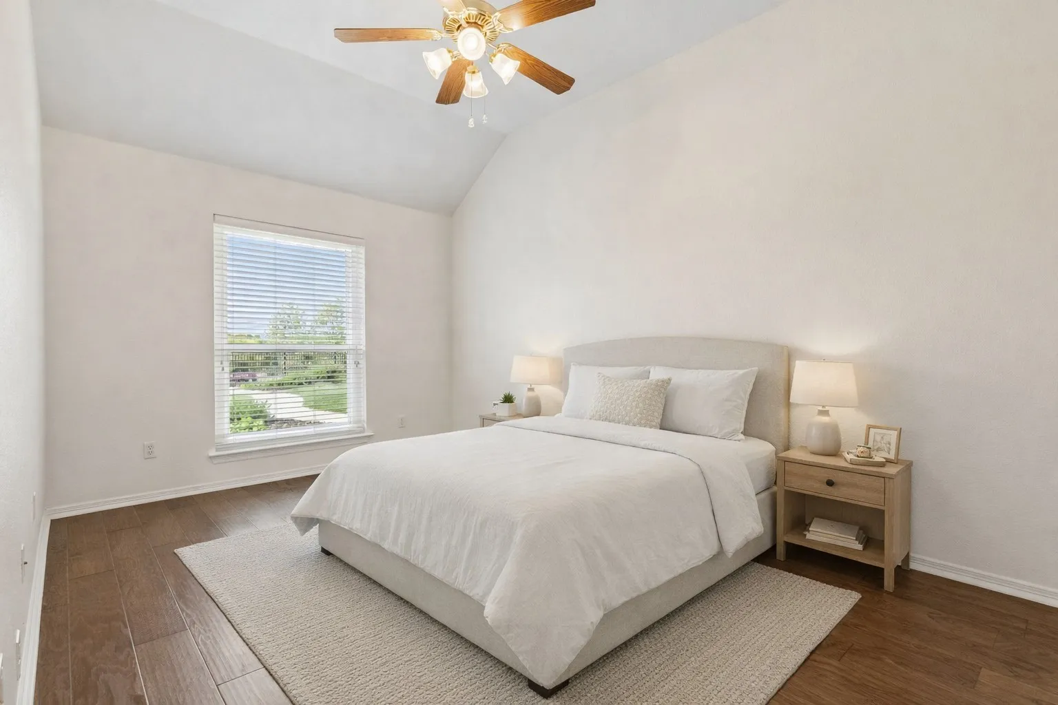 Comfortable Bedroom With Wood Floors And Ceiling Fan