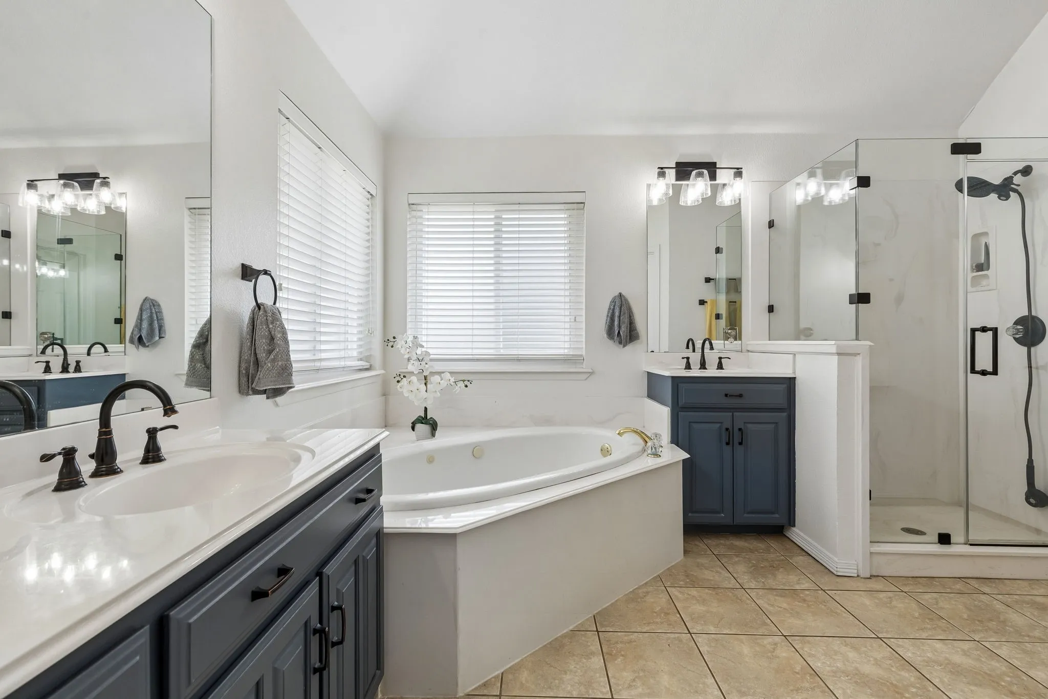 Primary Bath Featuring Jetted Soaking Tub, Dual Vanities, And Walk-In Closet