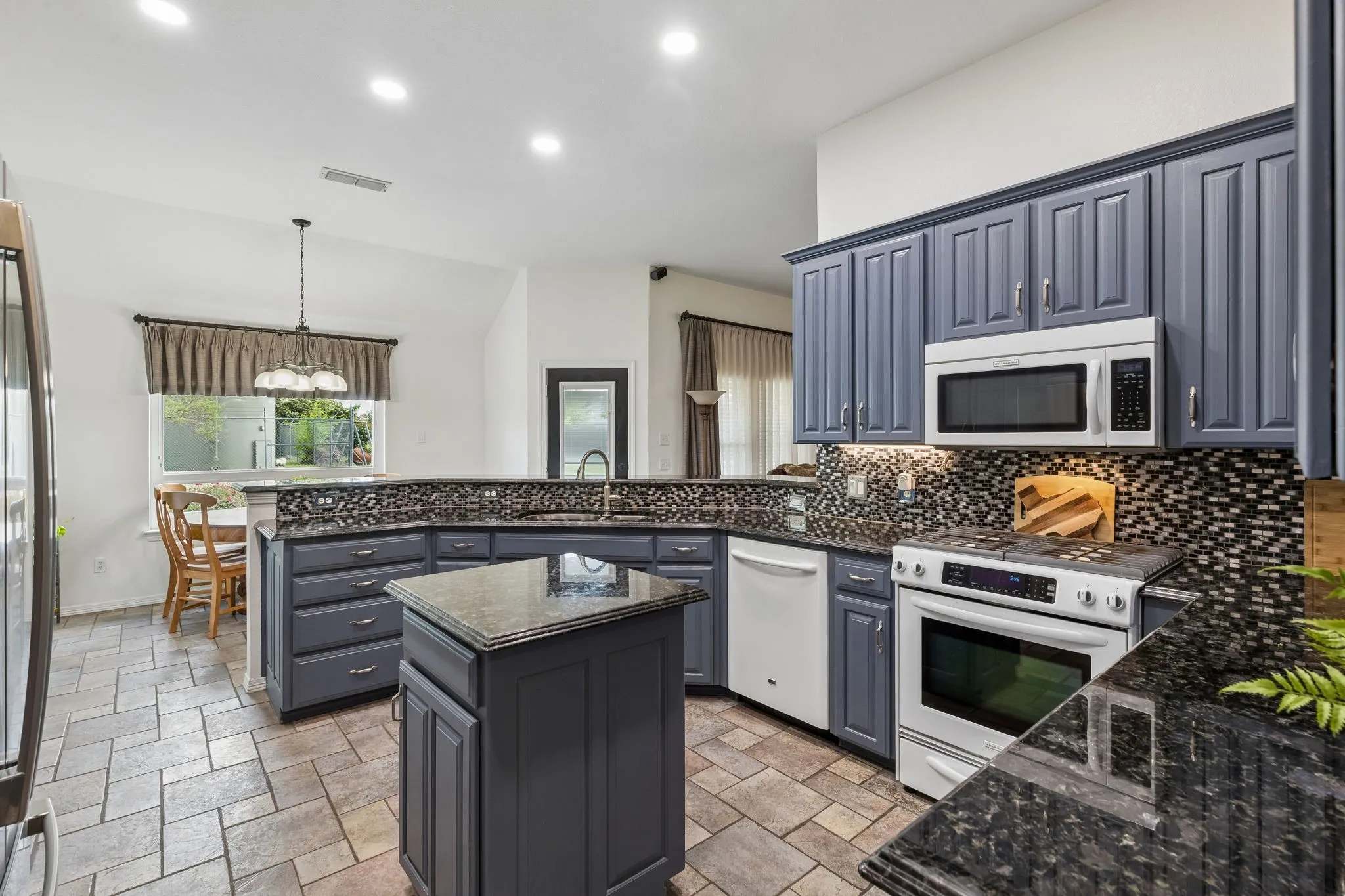Stylish Kitchen With Custom Cabinetry, Granite Counters, And Modern Mosaic Backsplash