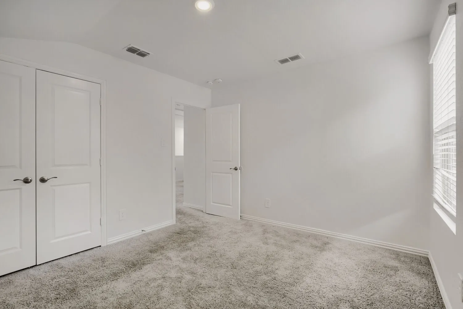 Room featuring light gray carpet flooring, white walls, and a window with​​‌​​​​‌​​‌‌​‌‌​​​‌‌​‌​‌​‌​​​‌​​ blinds
