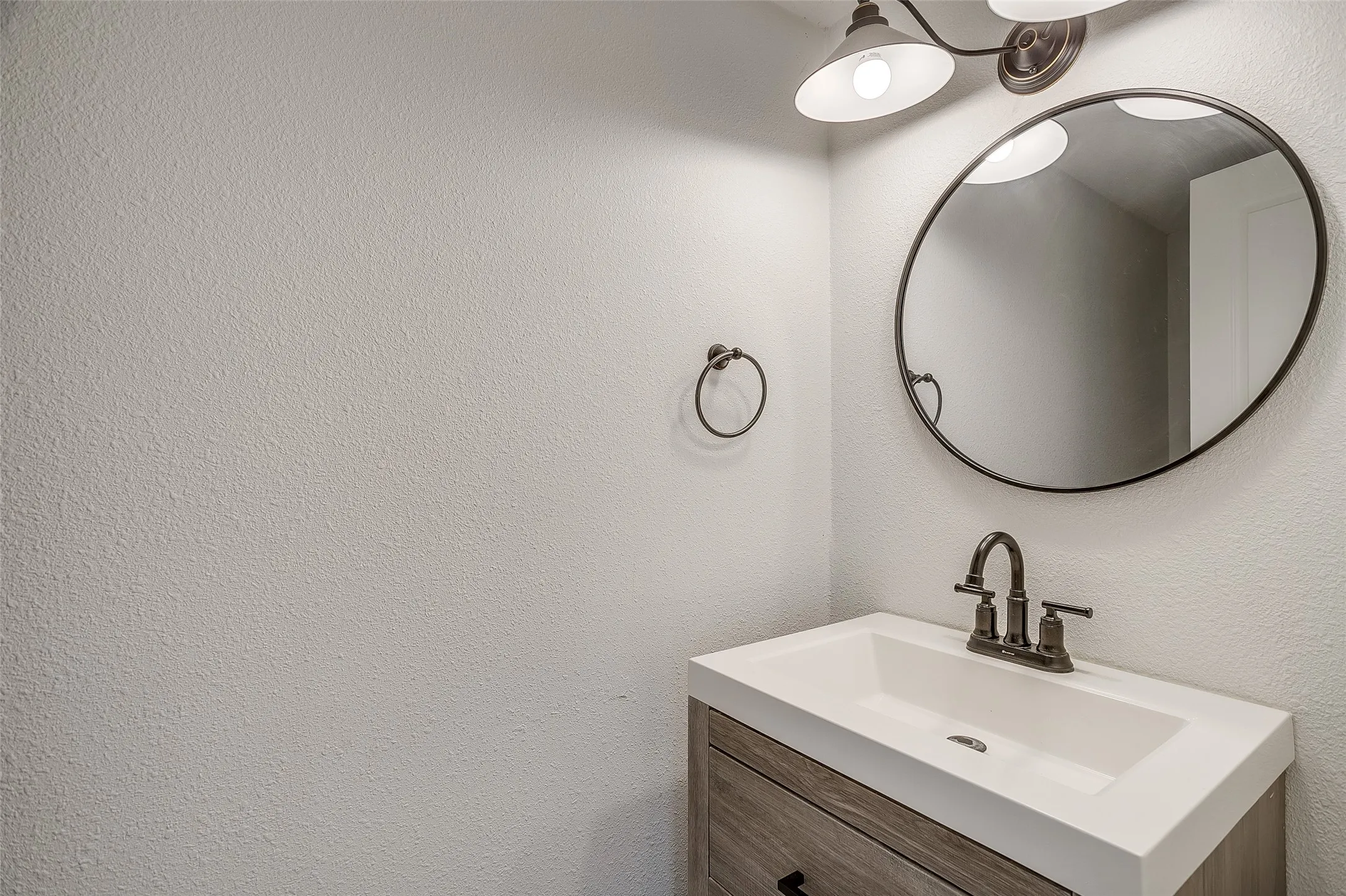 Half bath vanity with framed mirror and modern fixtures.