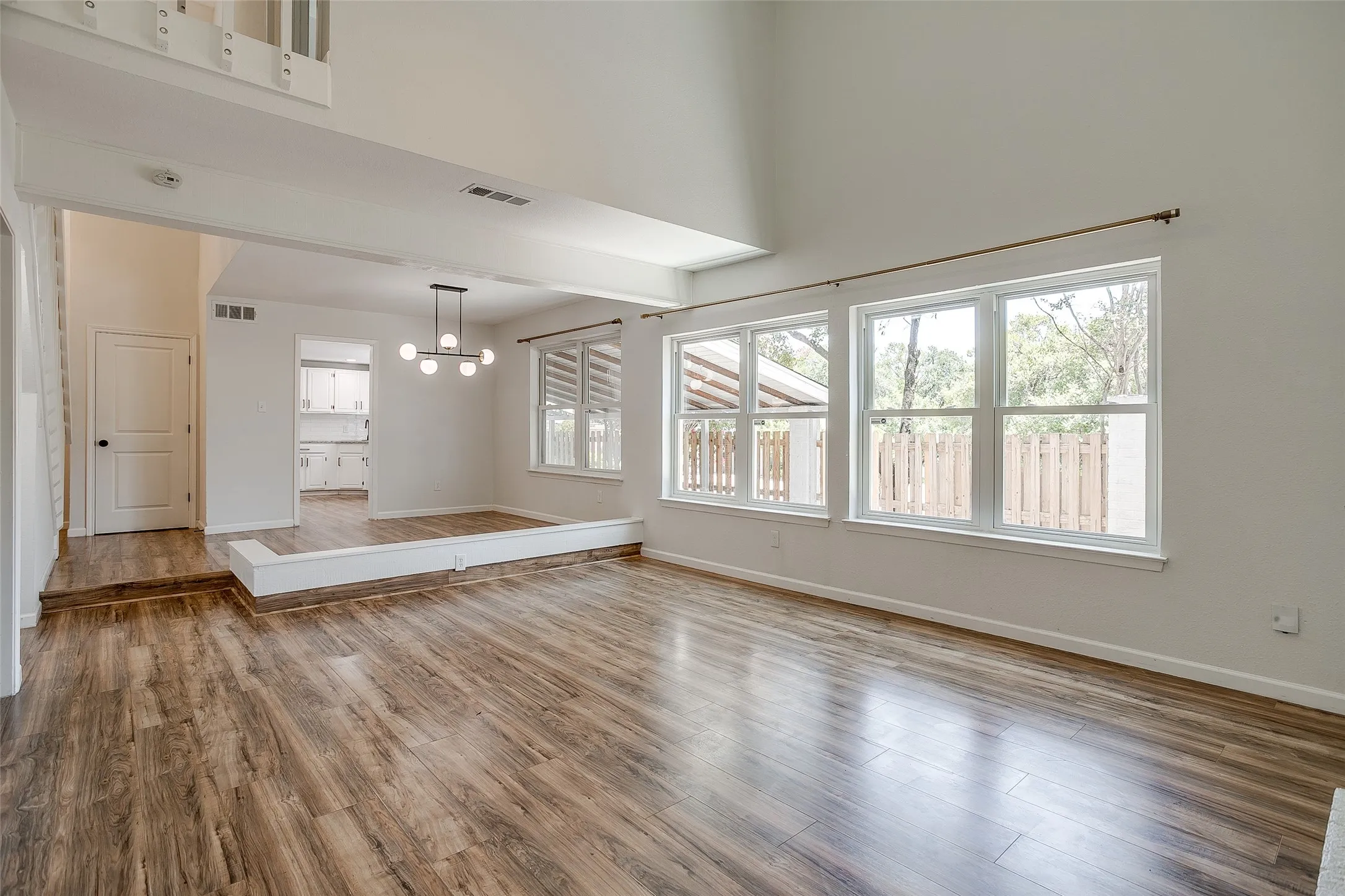 Open living and dining area with a wall of windows facing the backyard.