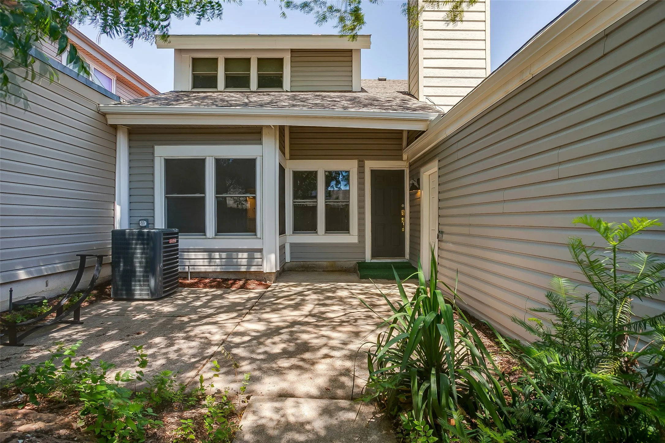 Rear exterior with covered porch and easy-care landscaping.