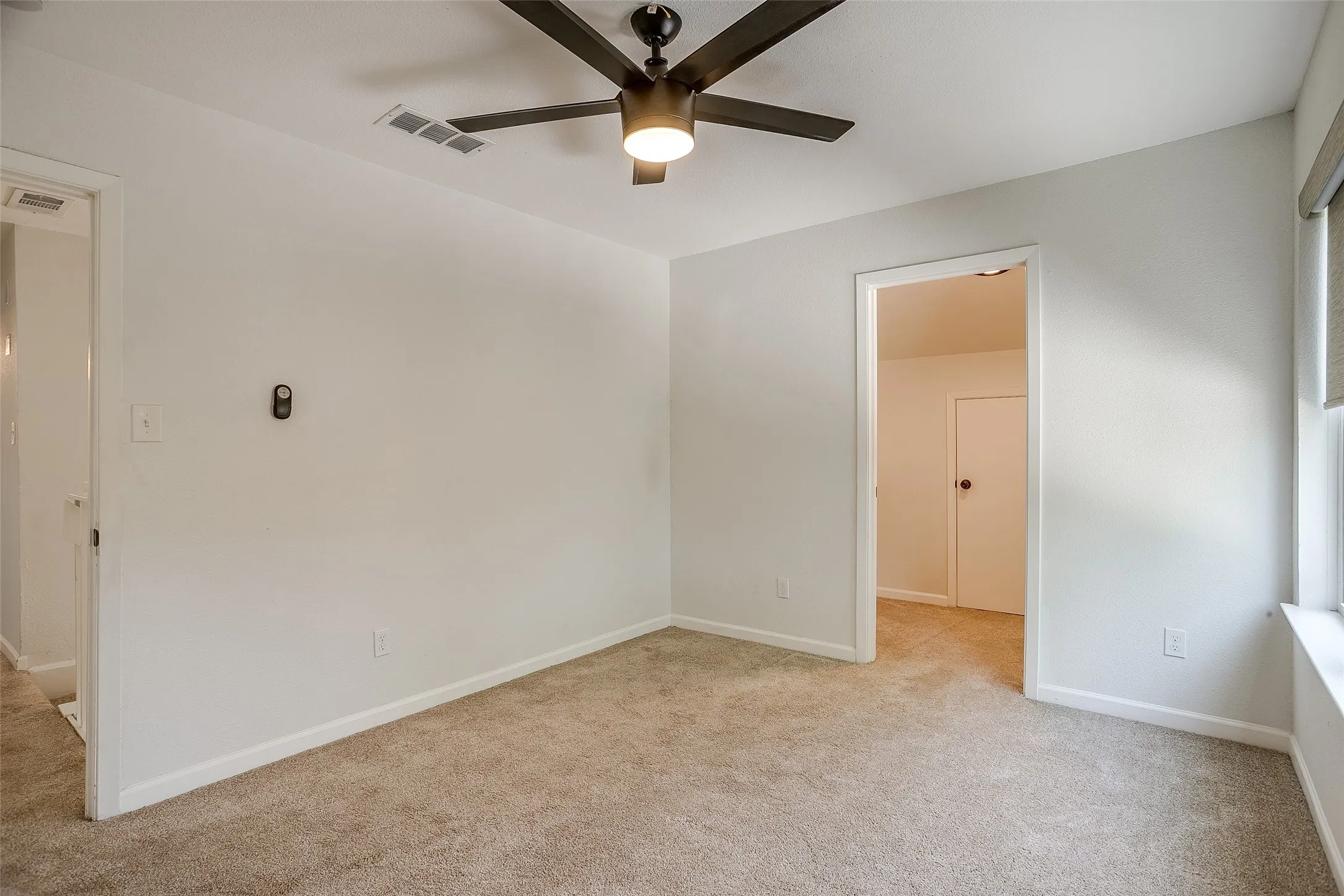 Roomy second bedroom with ceiling fan and closet.