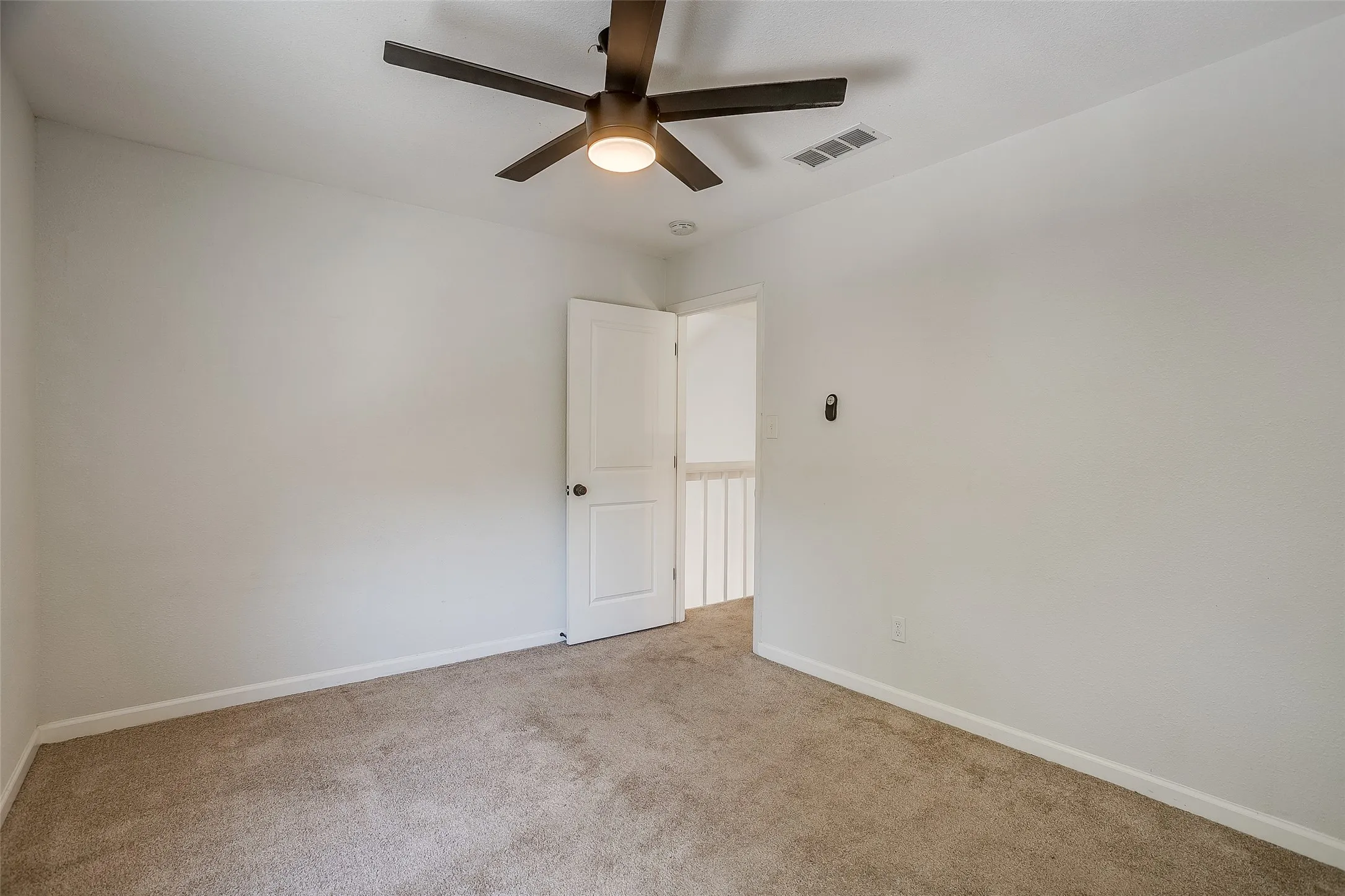 Roomy second bedroom with ceiling fan and closet.